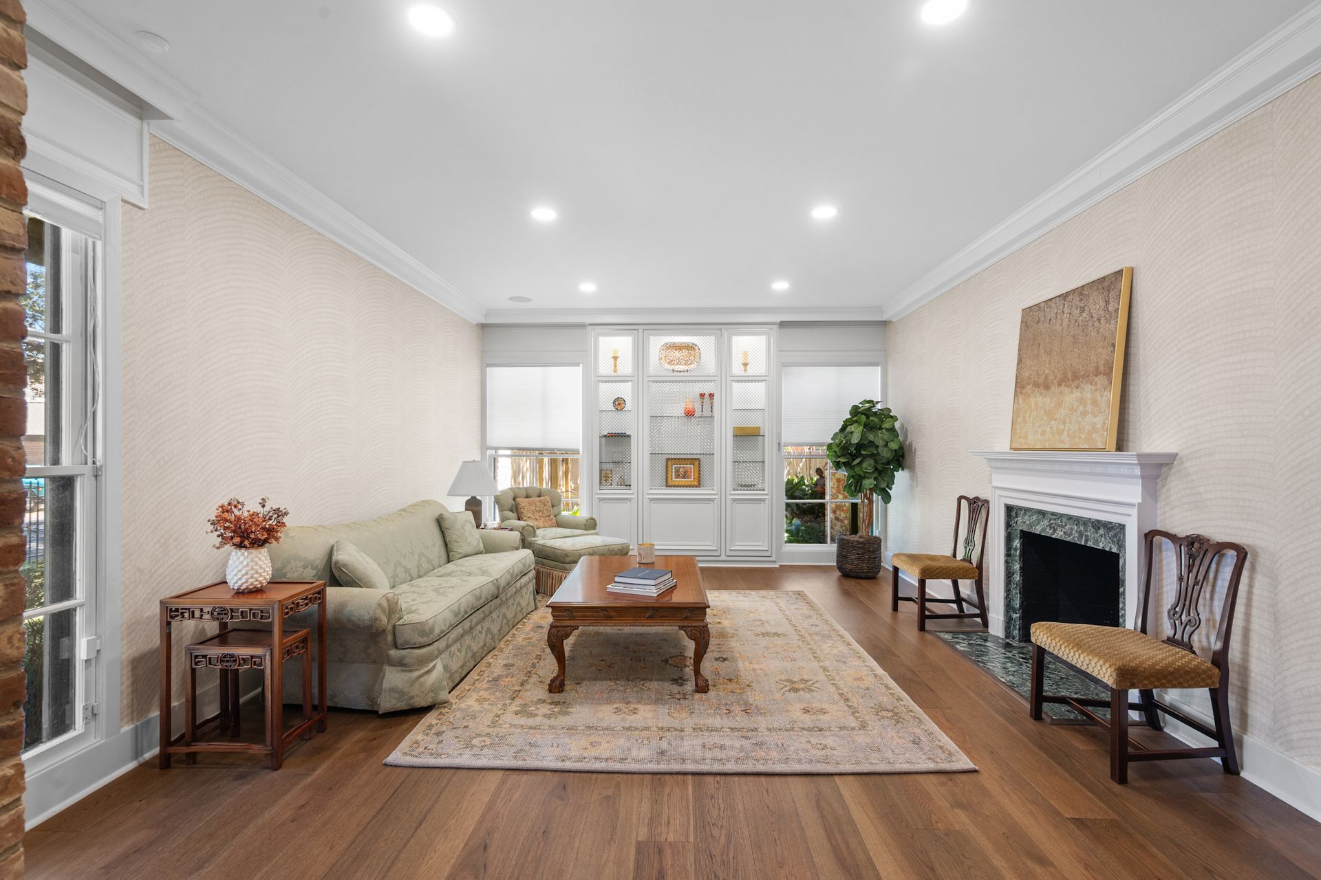 A living room with a couch , coffee table , chairs and a fireplace.
