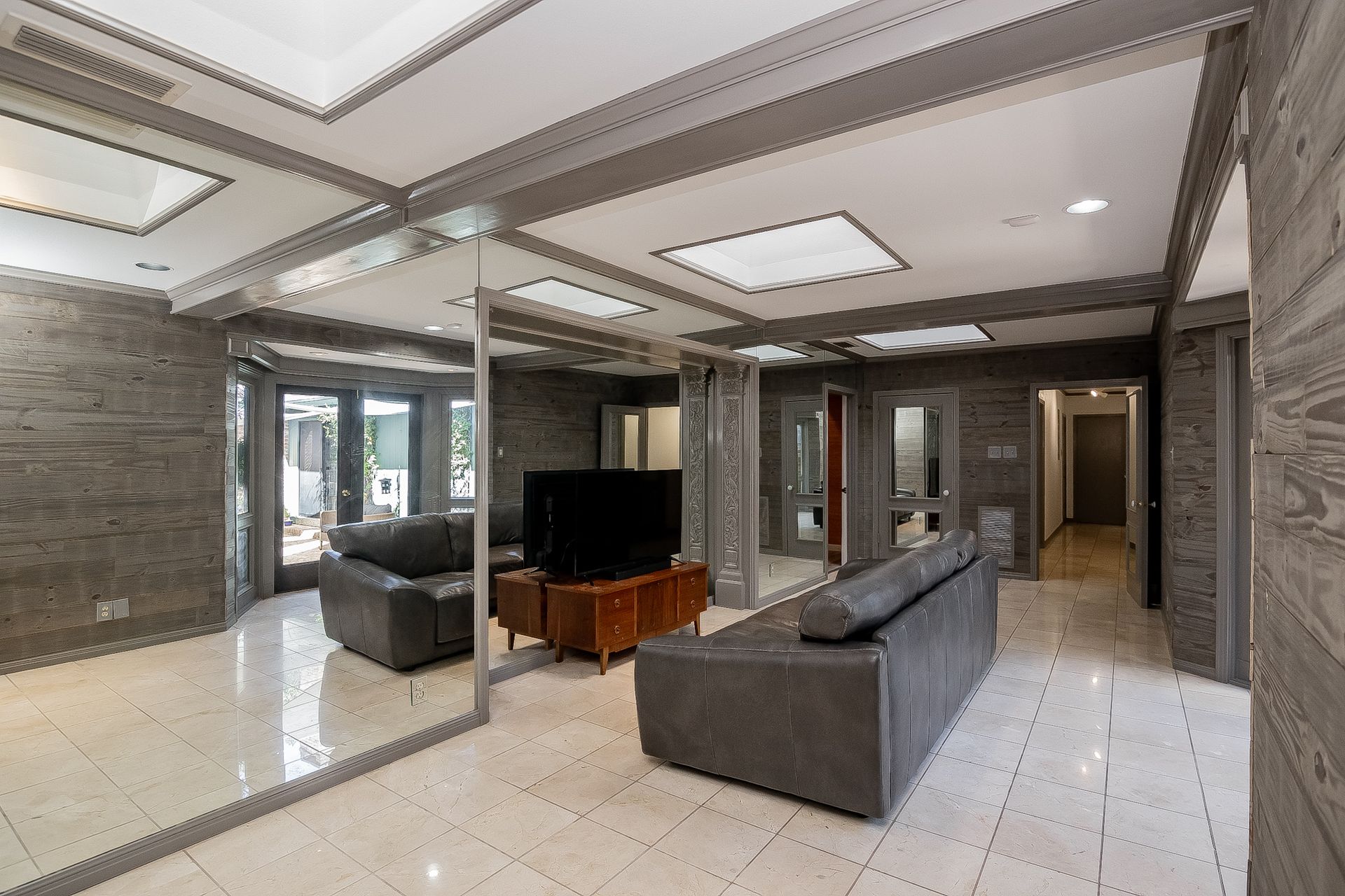 A living room with a couch , chairs , and a flat screen tv.