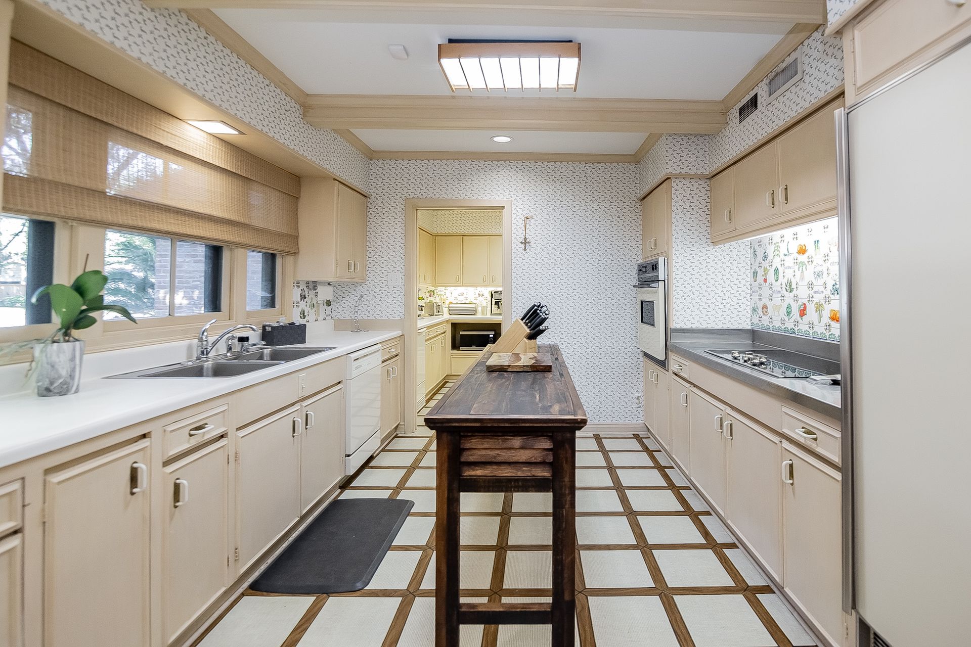A long kitchen with a wooden table in the middle