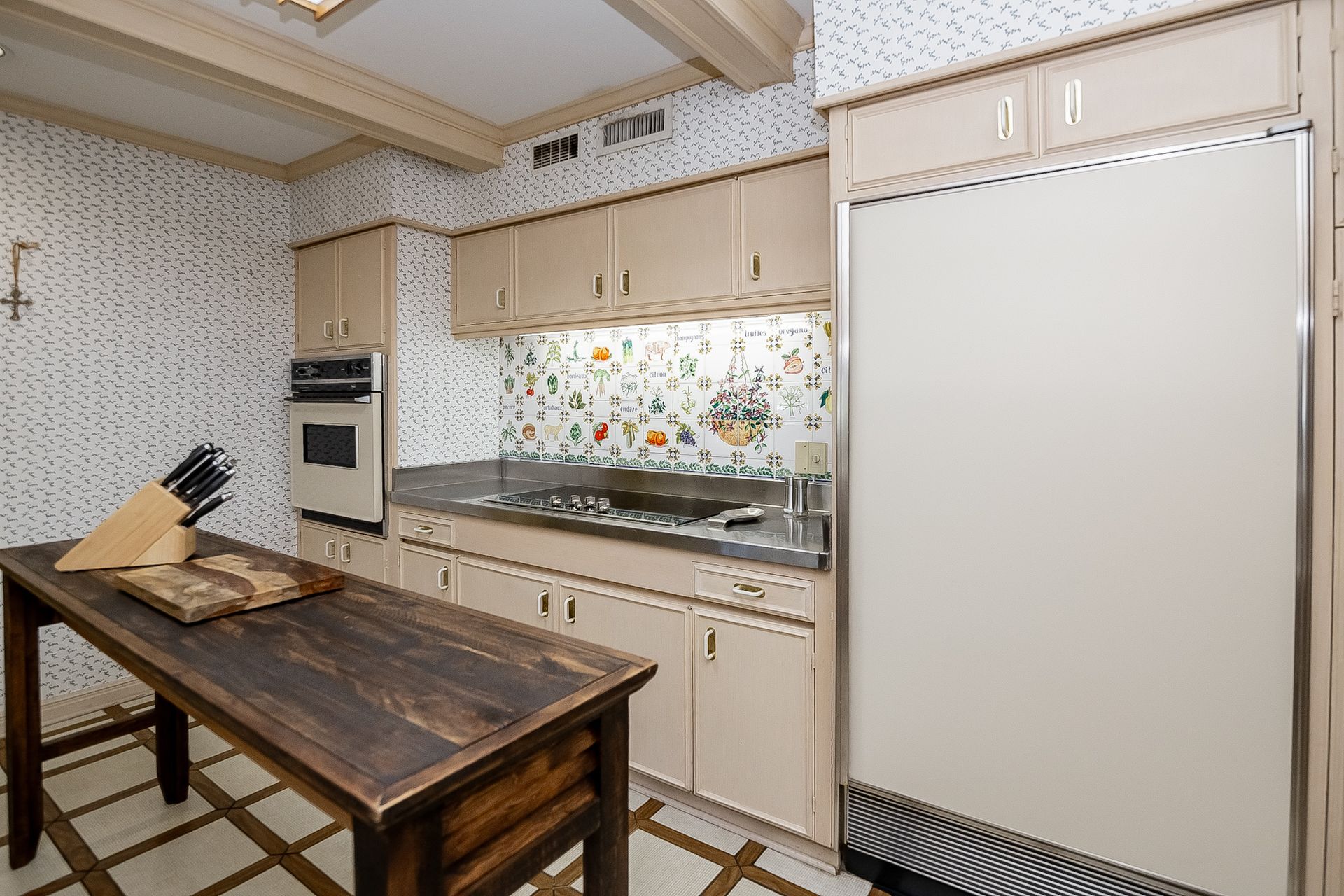 A kitchen with a wooden table and a stainless steel refrigerator