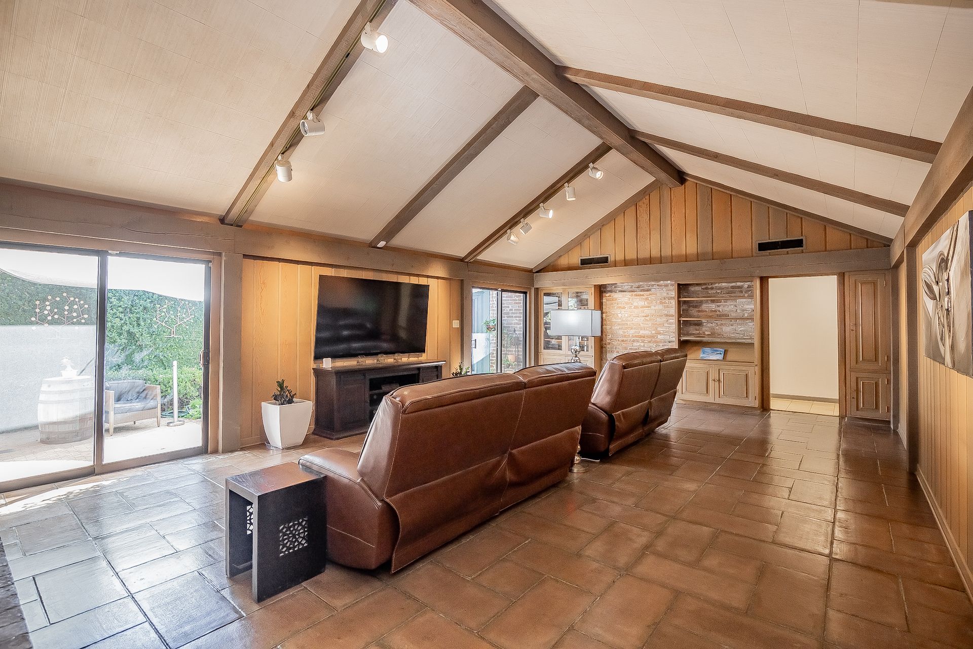 A living room with a couch , chairs and a television.