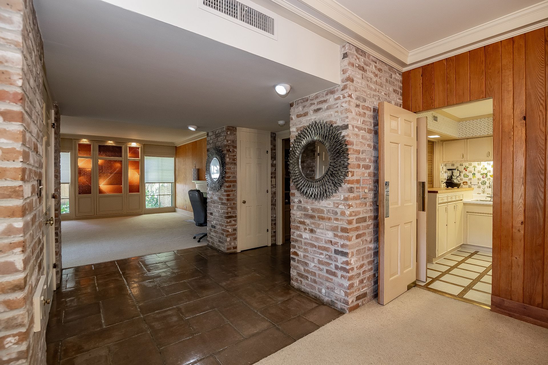 A hallway in a house with a brick wall and wood paneling