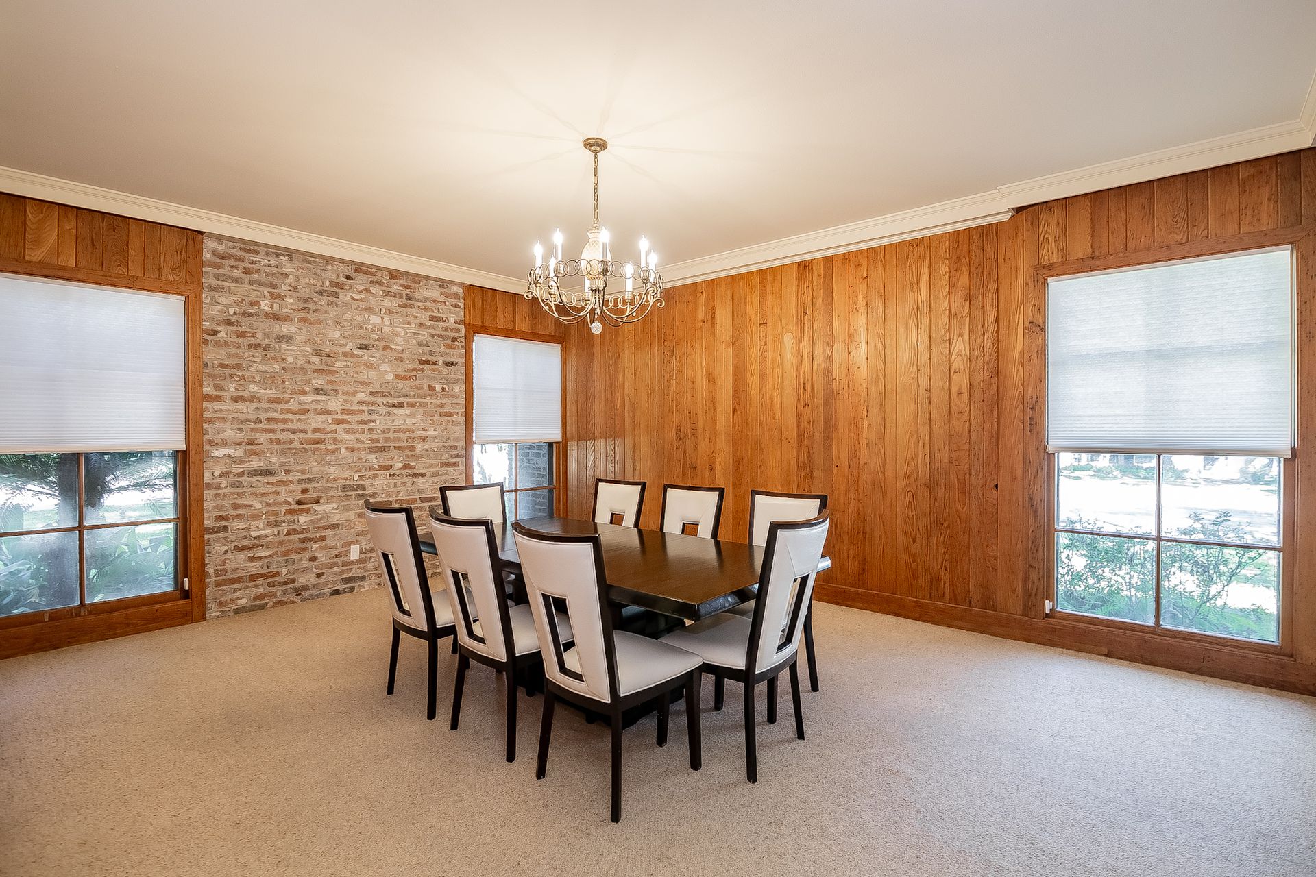 A dining room with a table and chairs and a chandelier.