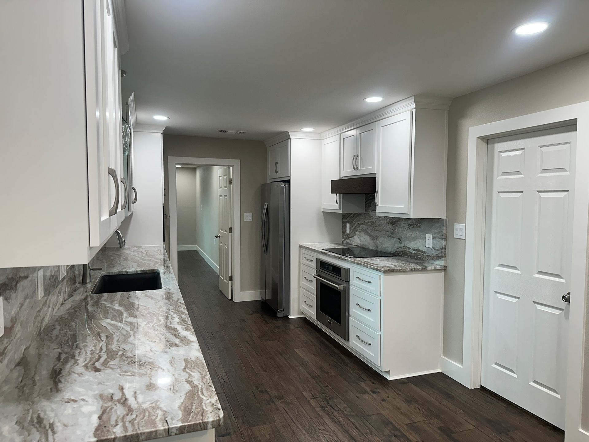 A kitchen with white cabinets and granite counter tops