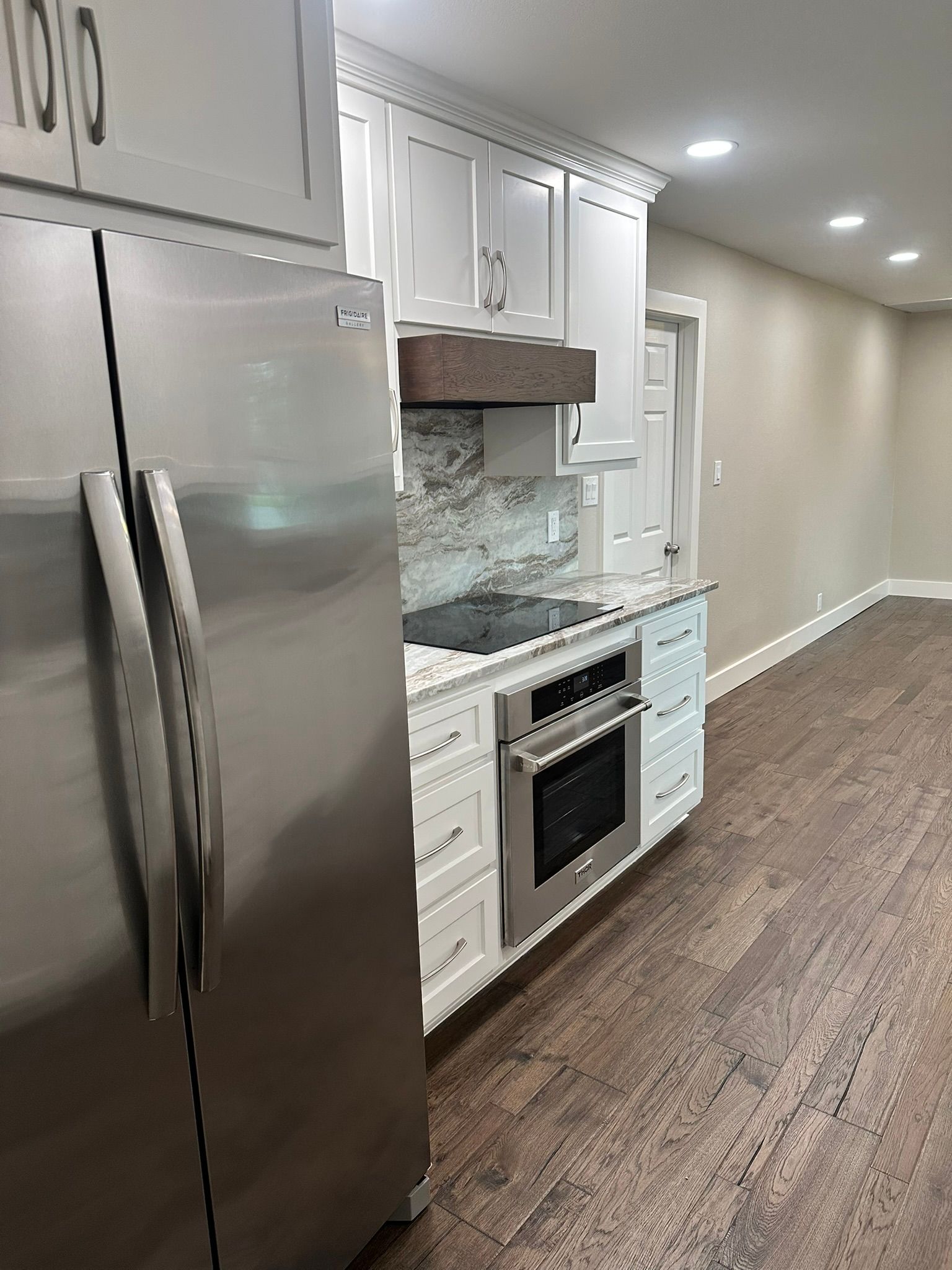 A kitchen with stainless steel appliances and white cabinets.
