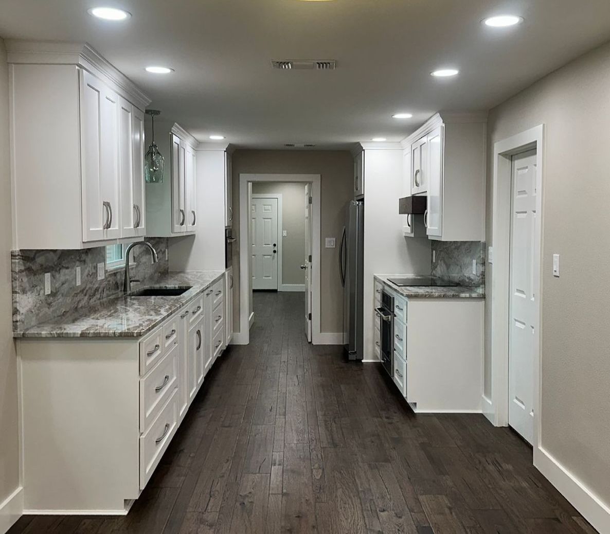 A kitchen with white cabinets and granite counter tops