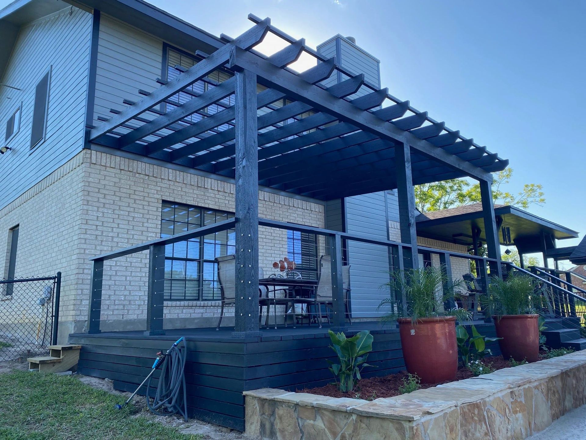 A house with a porch and a pergola on top of it.