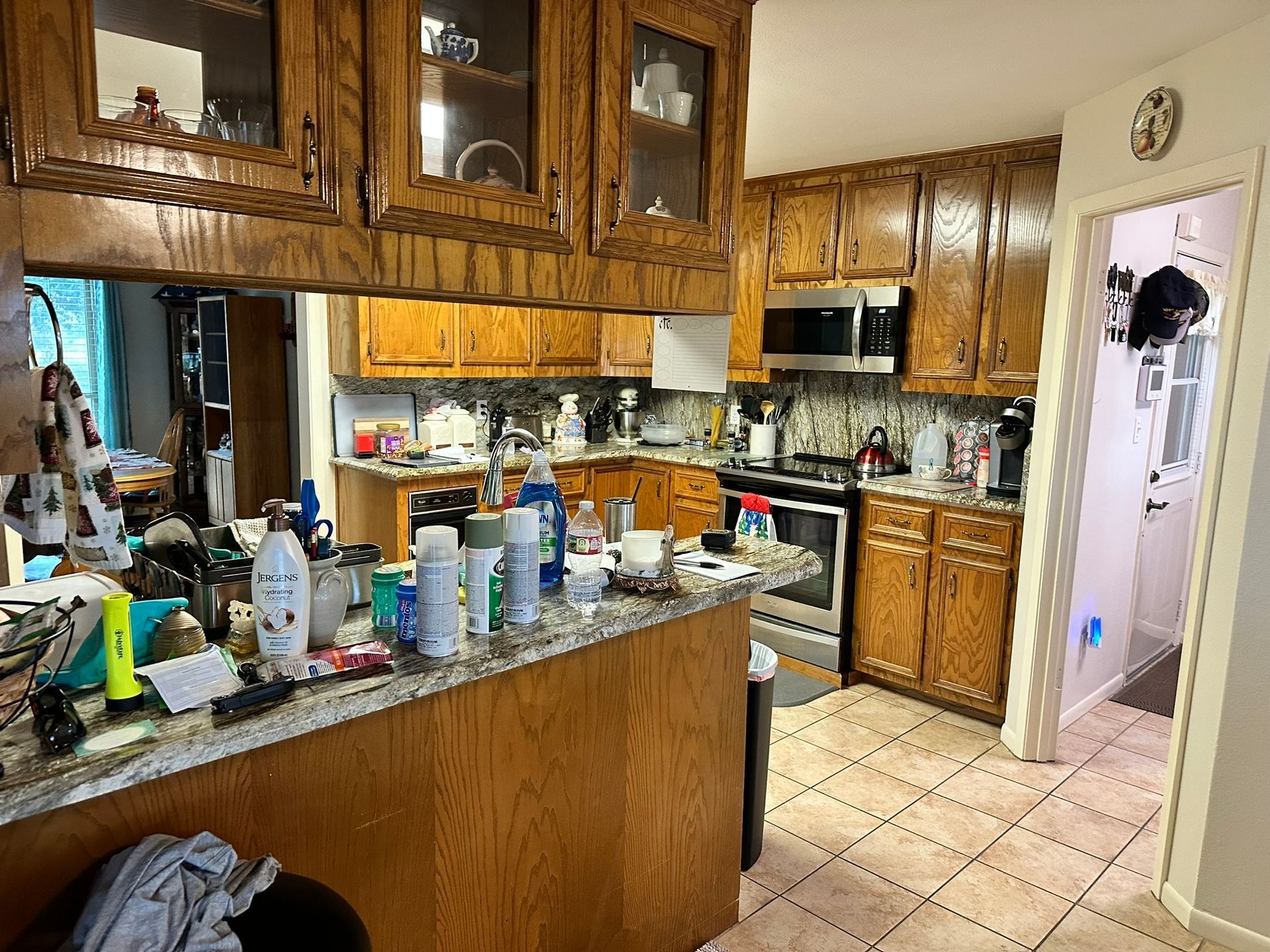 A kitchen with wooden cabinets , granite counter tops and stainless steel appliances.