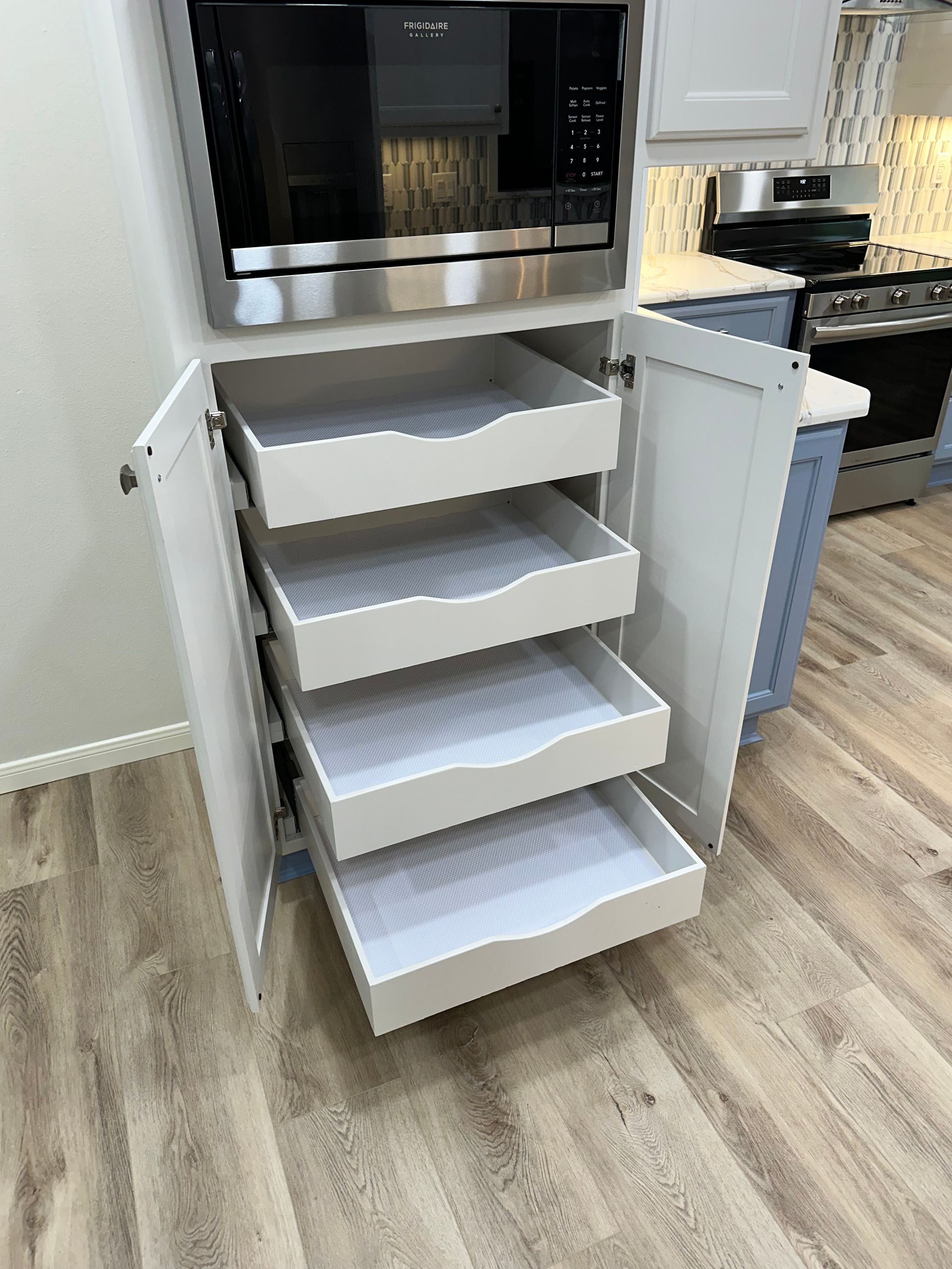 A kitchen with a microwave and four drawers in it.