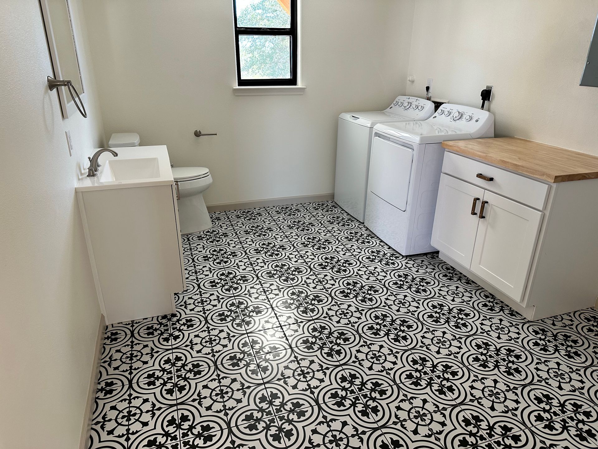 A laundry room with a washer and dryer , sink , and toilet.