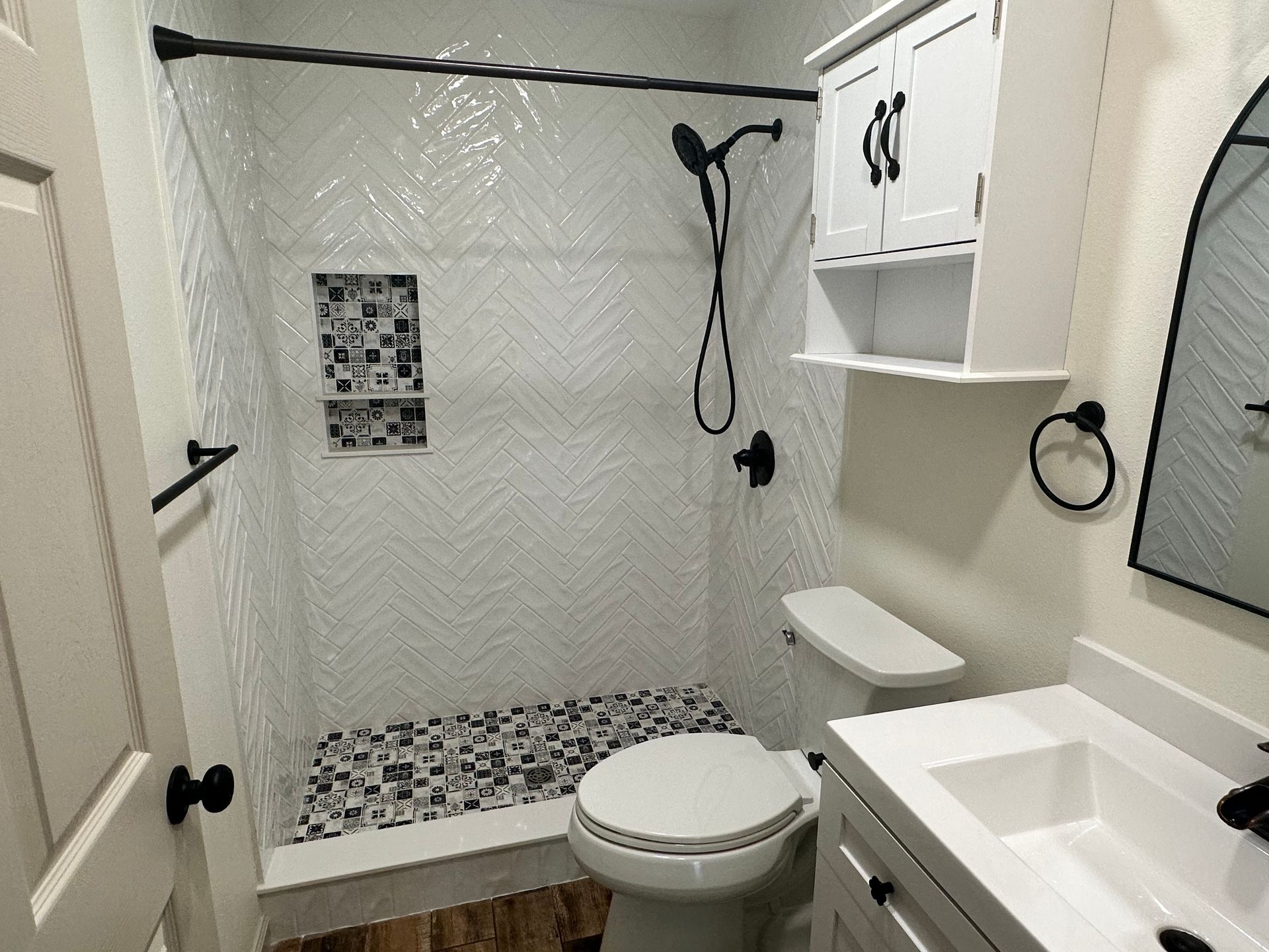 A bathroom with a toilet , sink and shower.