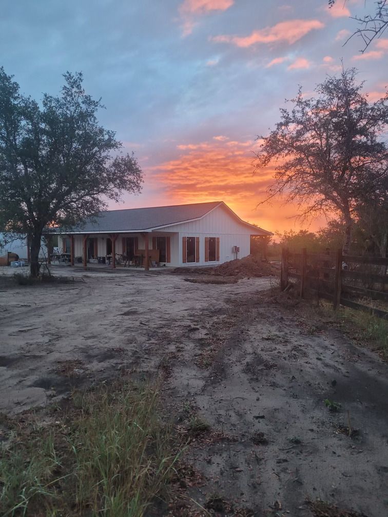 A house with a porch and a sunset in the background