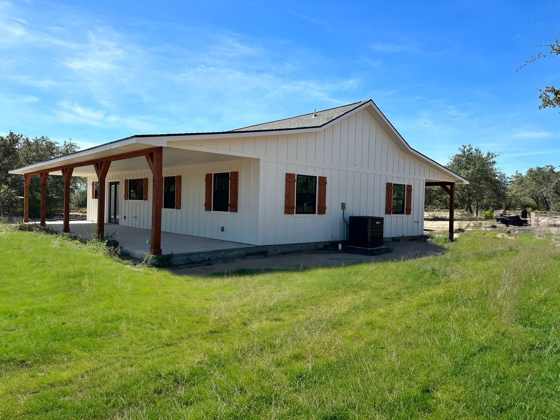 A white house with a porch and shutters on the windows