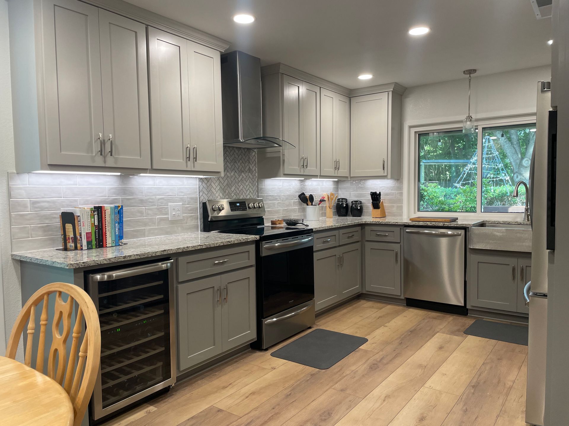 A kitchen with stainless steel appliances and gray cabinets.