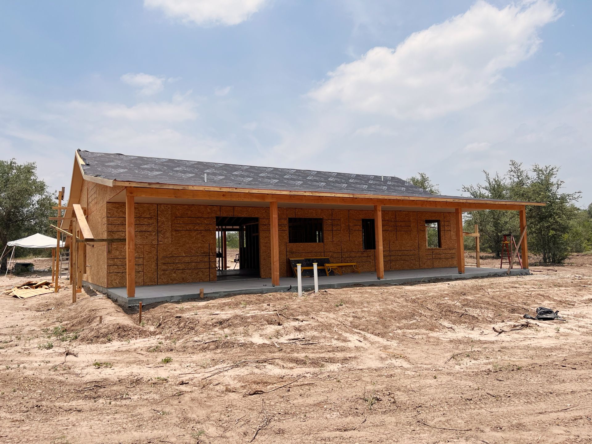 A house is being built in the middle of a dirt field