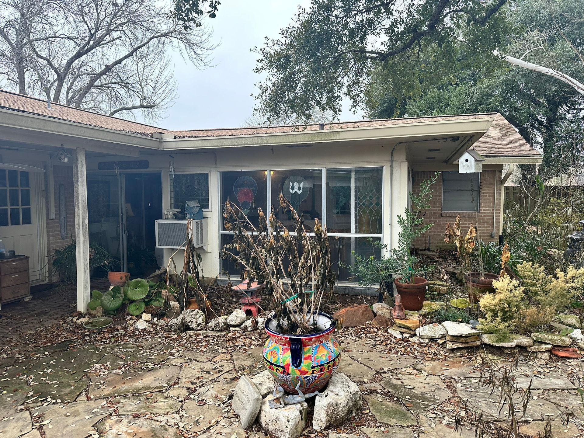 A house with a lot of potted plants in front of it.