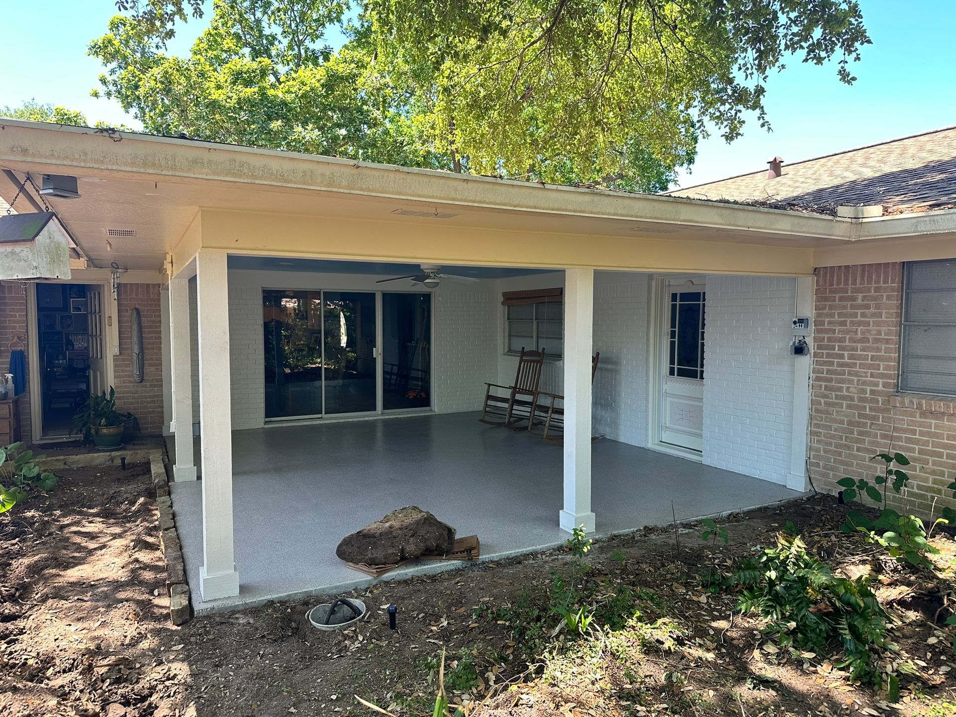 A house with a covered patio in front of it.