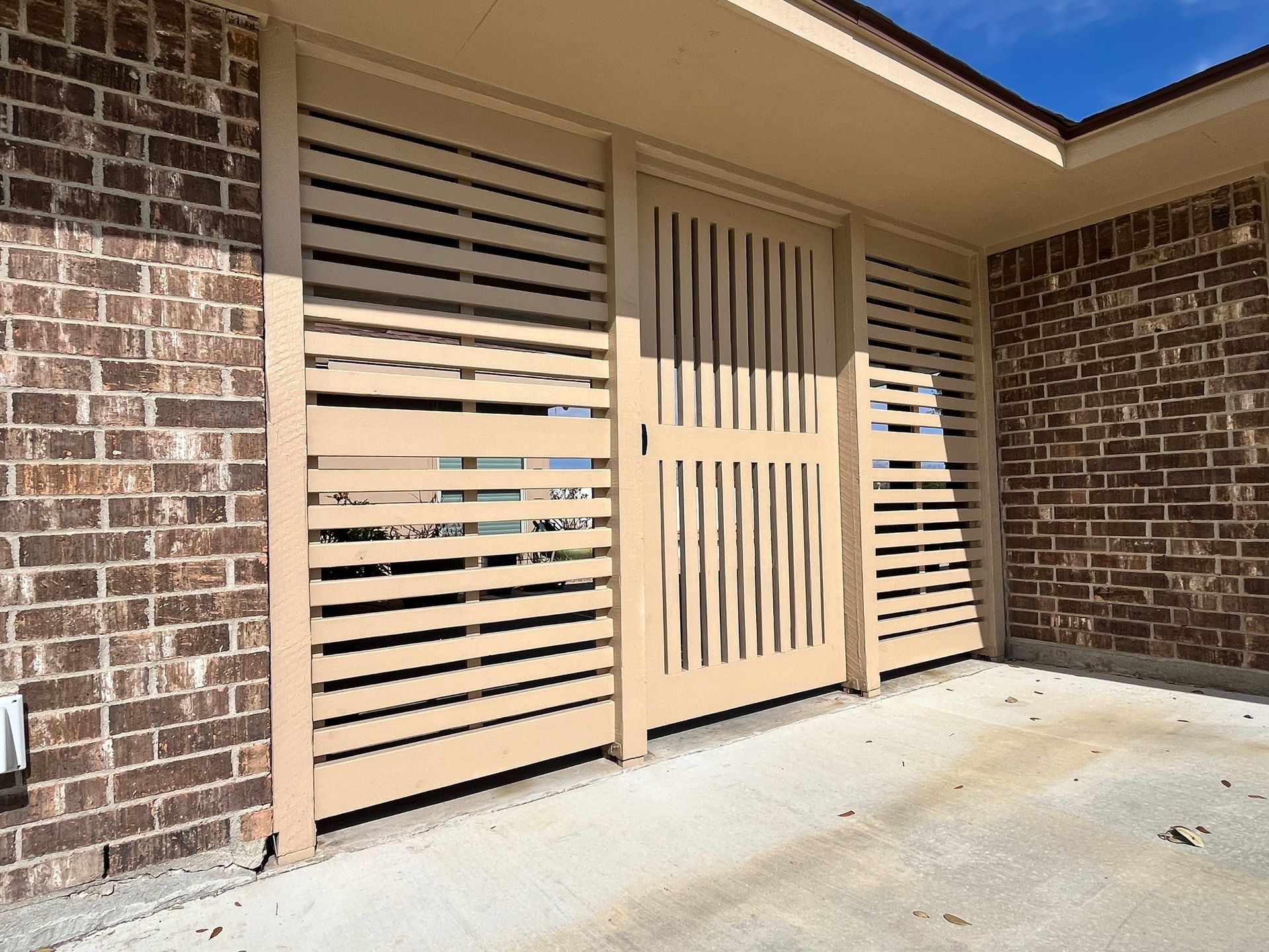 A brick building with a wooden gate in front of it