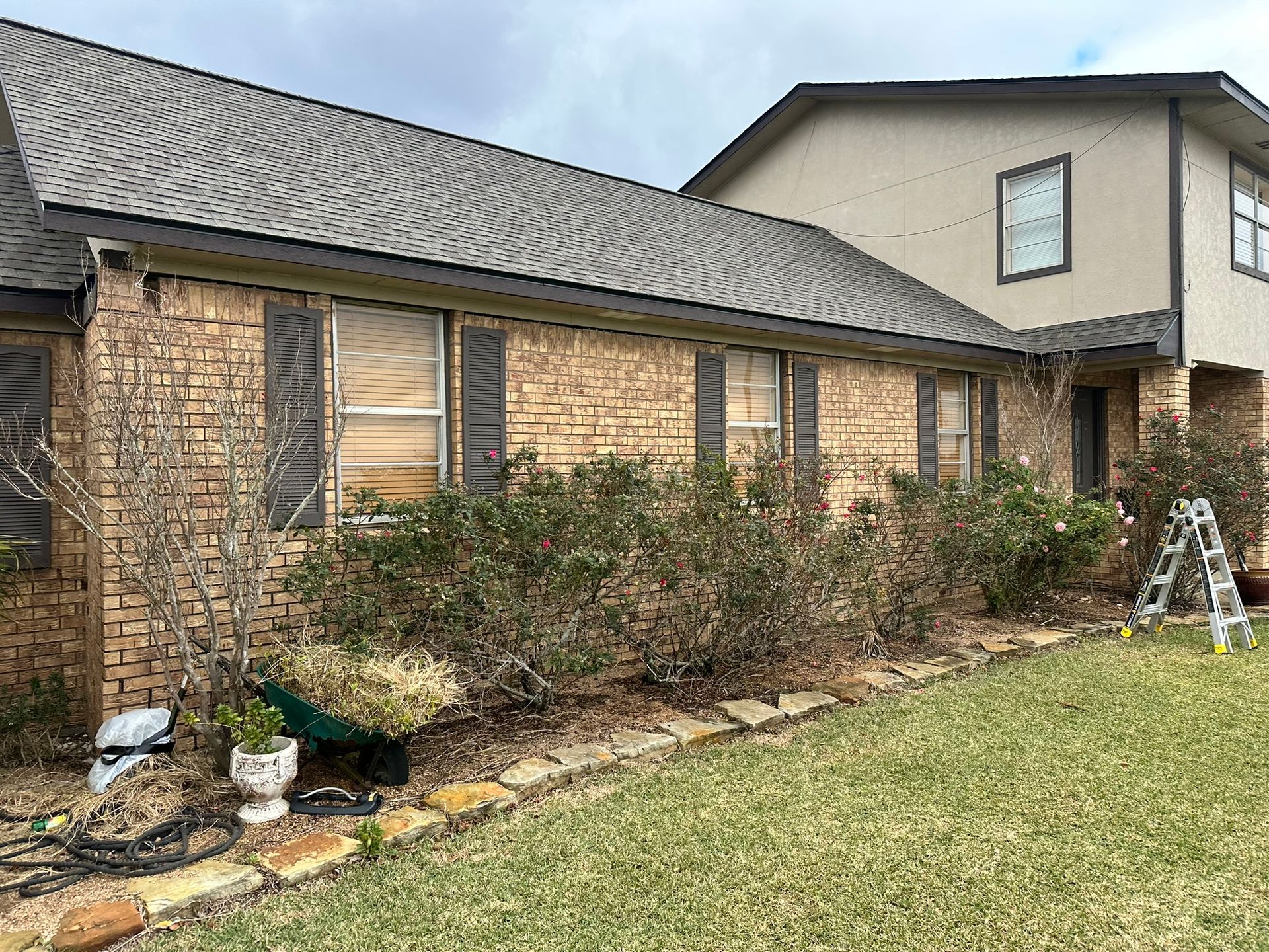 A large brick house with a ladder in front of it.