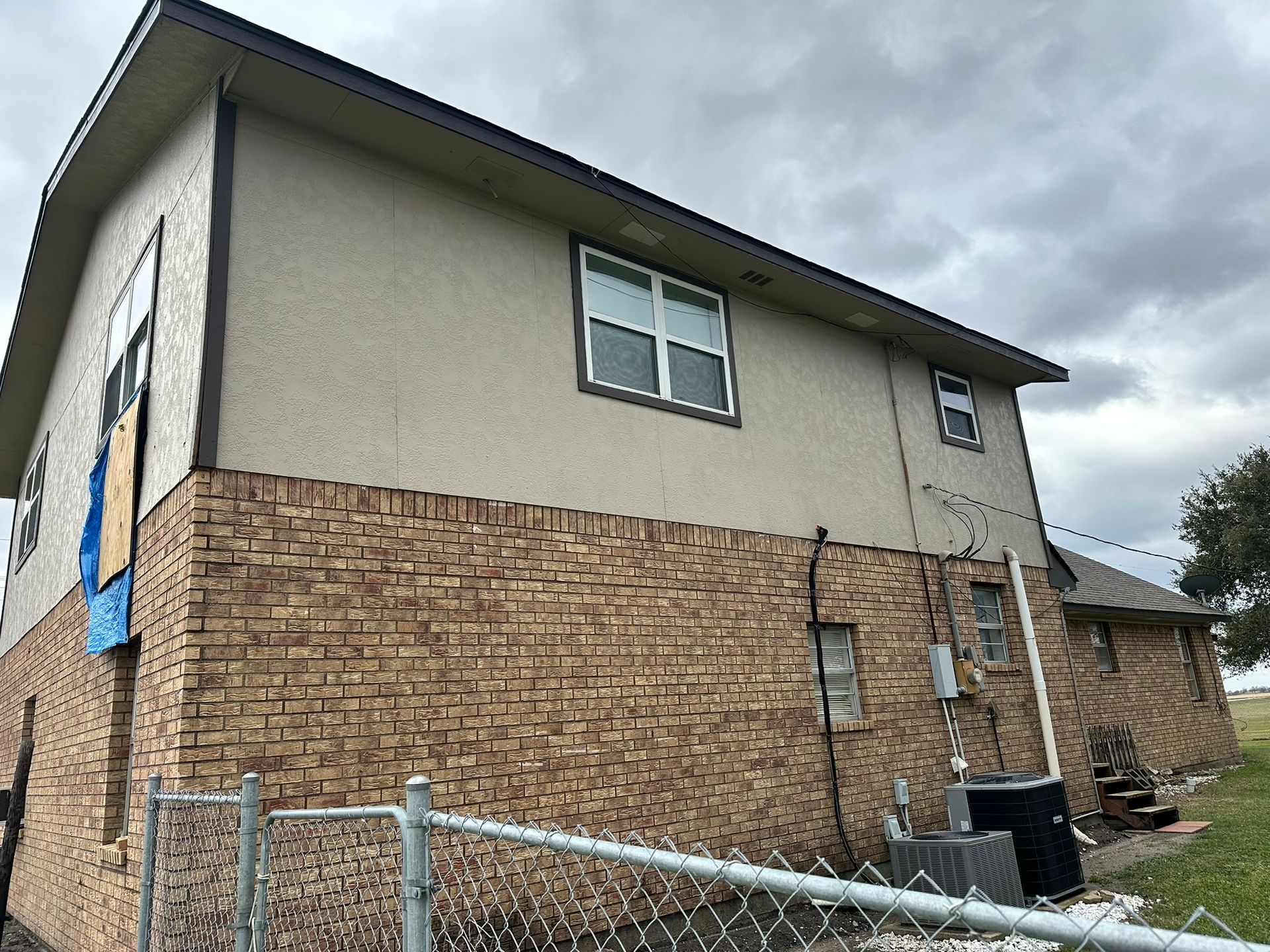 A brick house with a chain link fence in front of it.