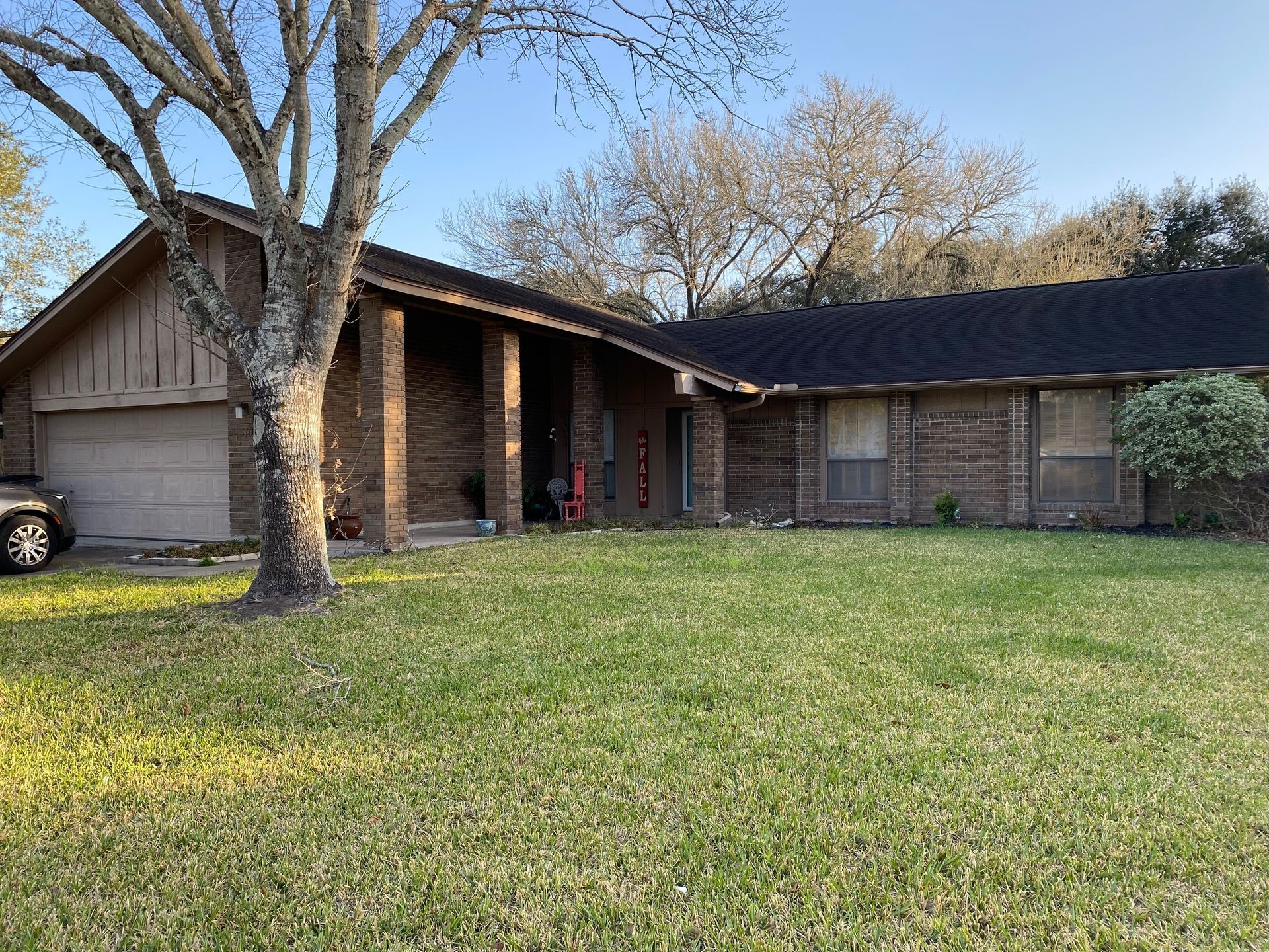 A brick house with a car parked in front of it.