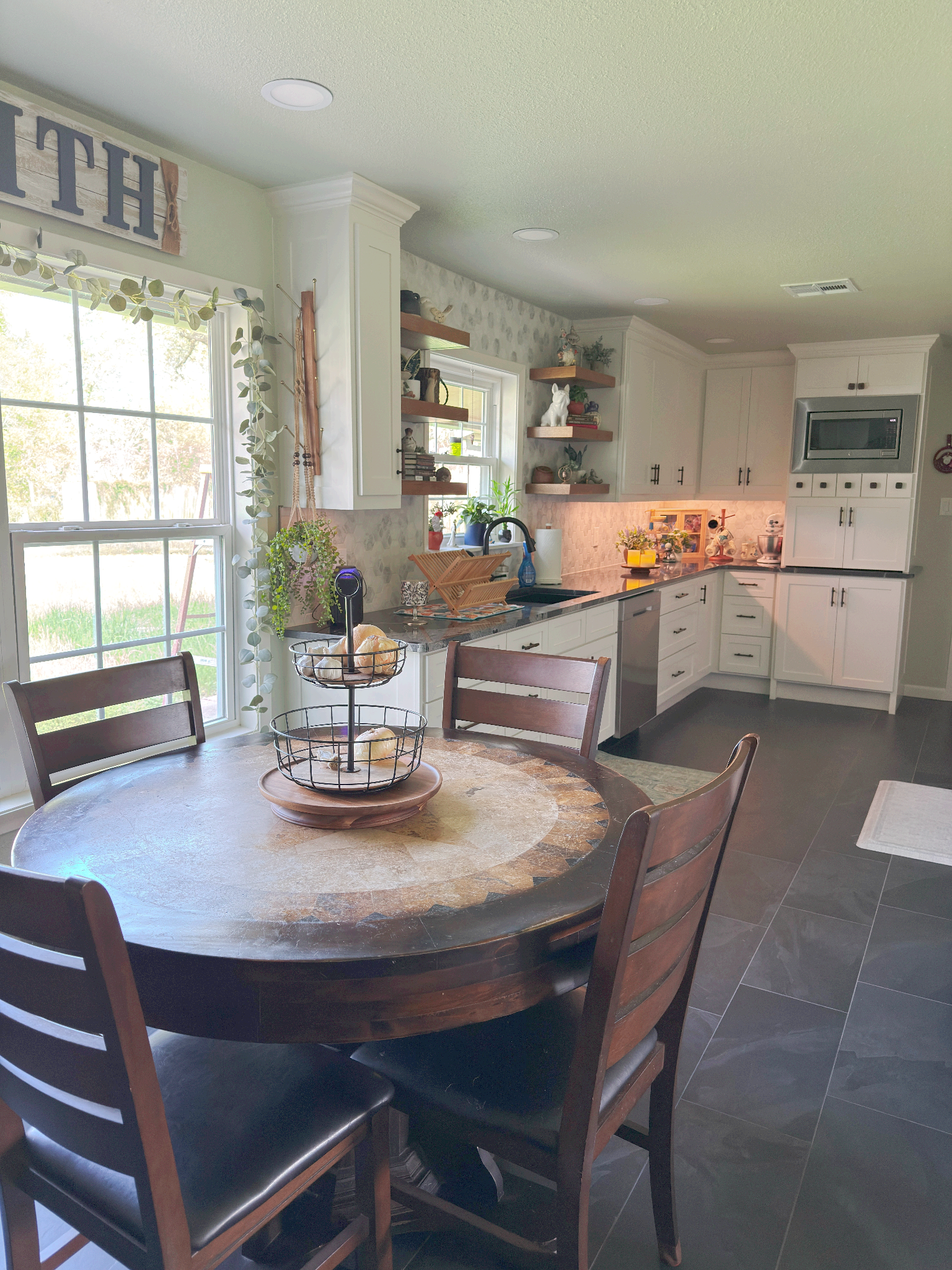 A kitchen with a round table and chairs in it.