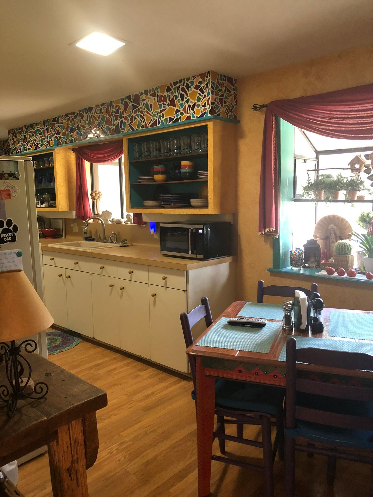 A kitchen with a table and chairs and a refrigerator.