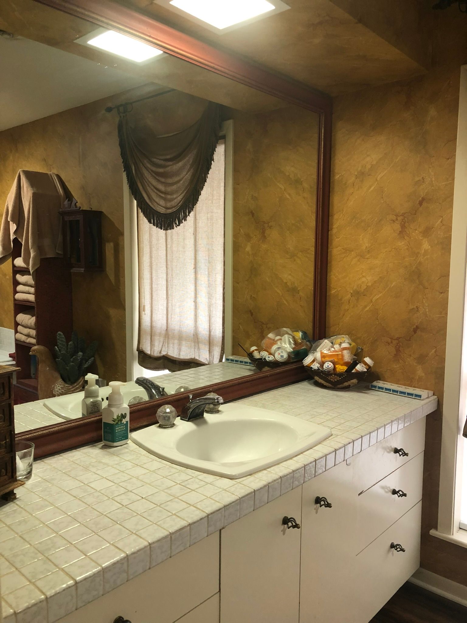 A bathroom with a sink and a large mirror