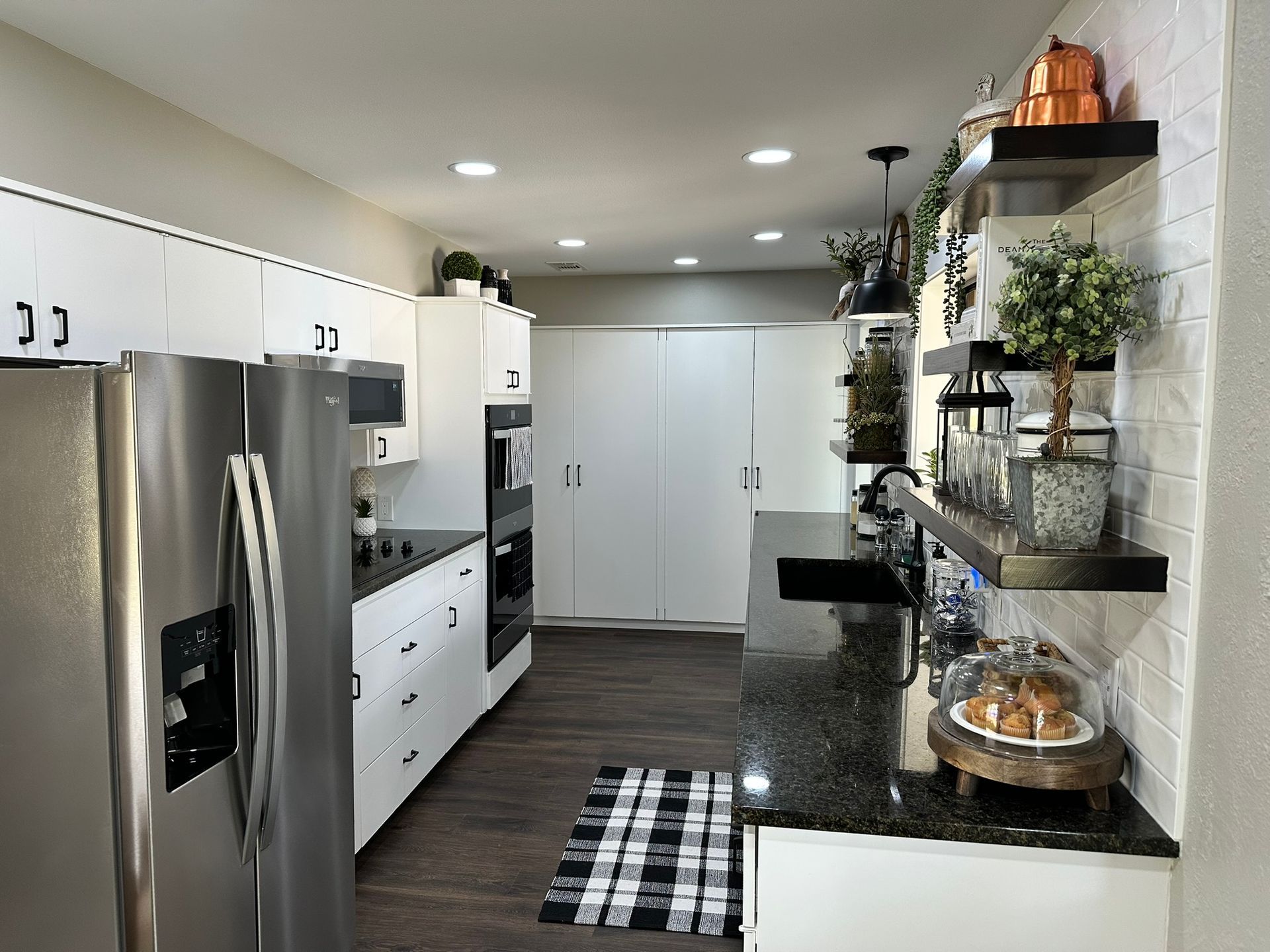 A kitchen with stainless steel appliances and white cabinets