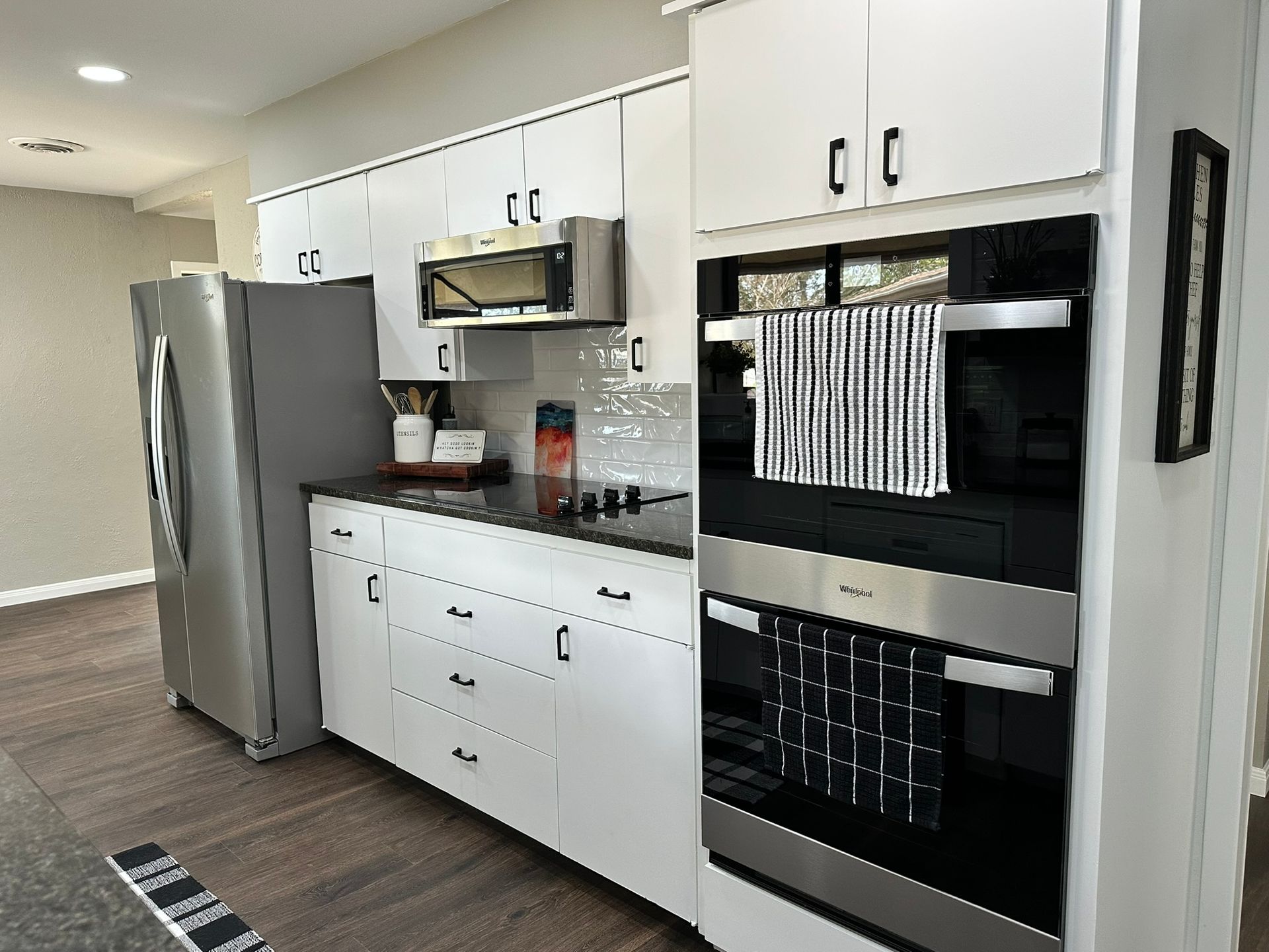 A kitchen with white cabinets and stainless steel appliances