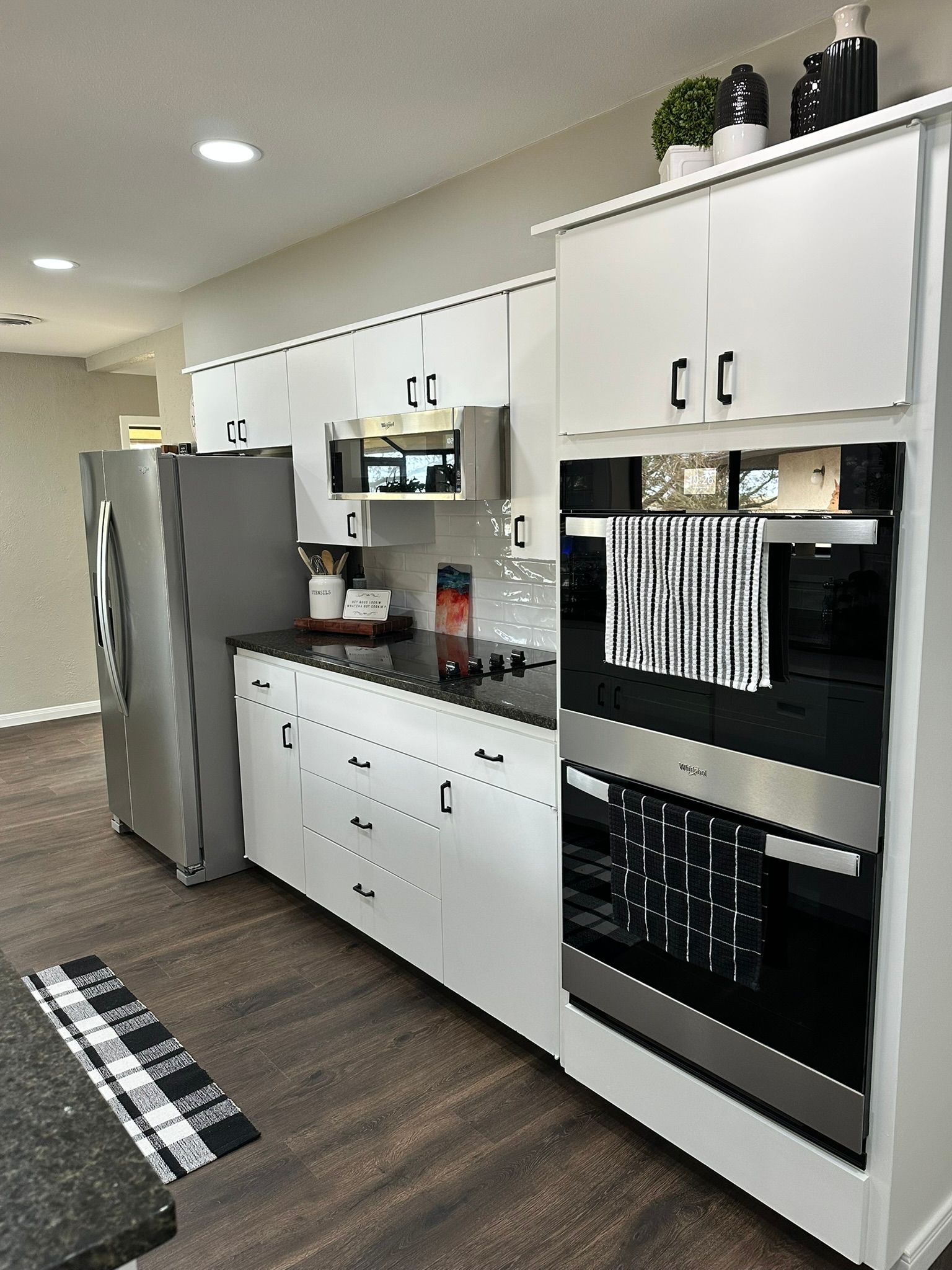 A kitchen with white cabinets and stainless steel appliances.
