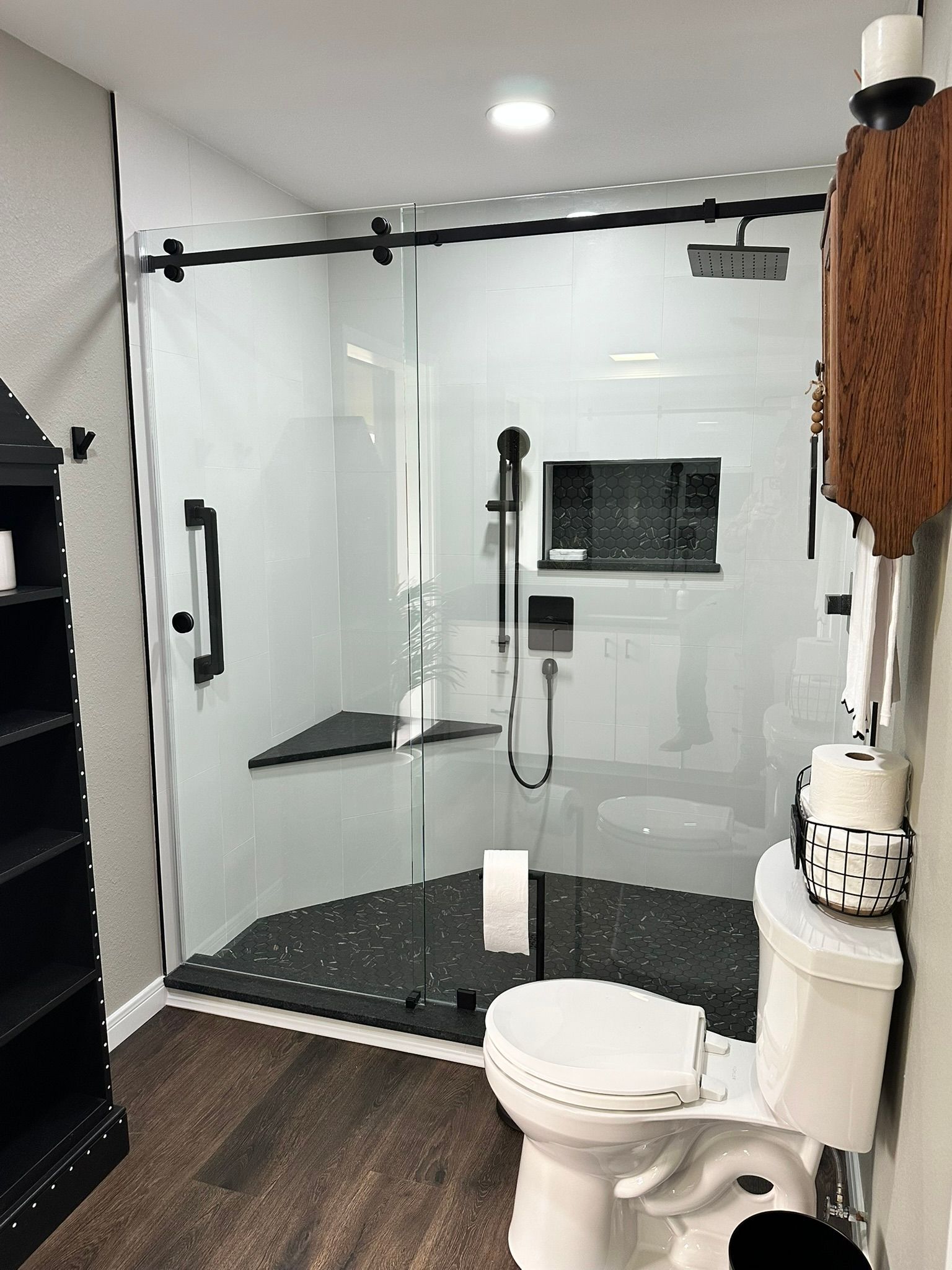 A bathroom with a toilet , shower and sliding glass door.
