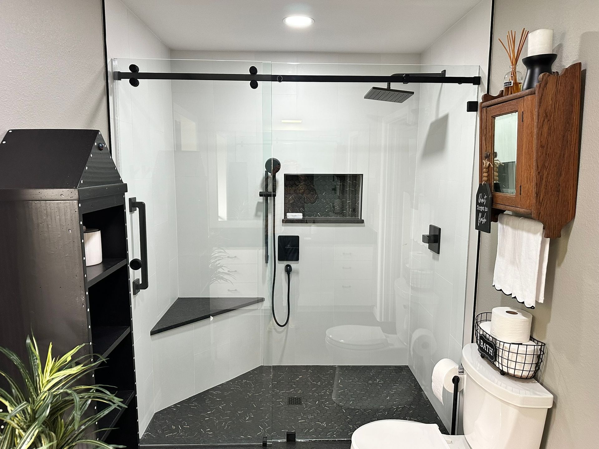 A bathroom with a toilet , shower , and mirror.