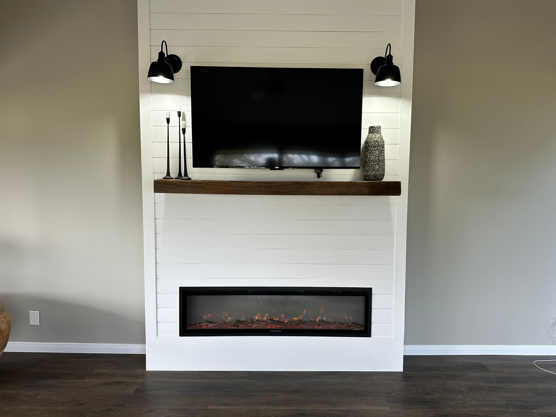 A living room with a fireplace and a flat screen tv on the wall.