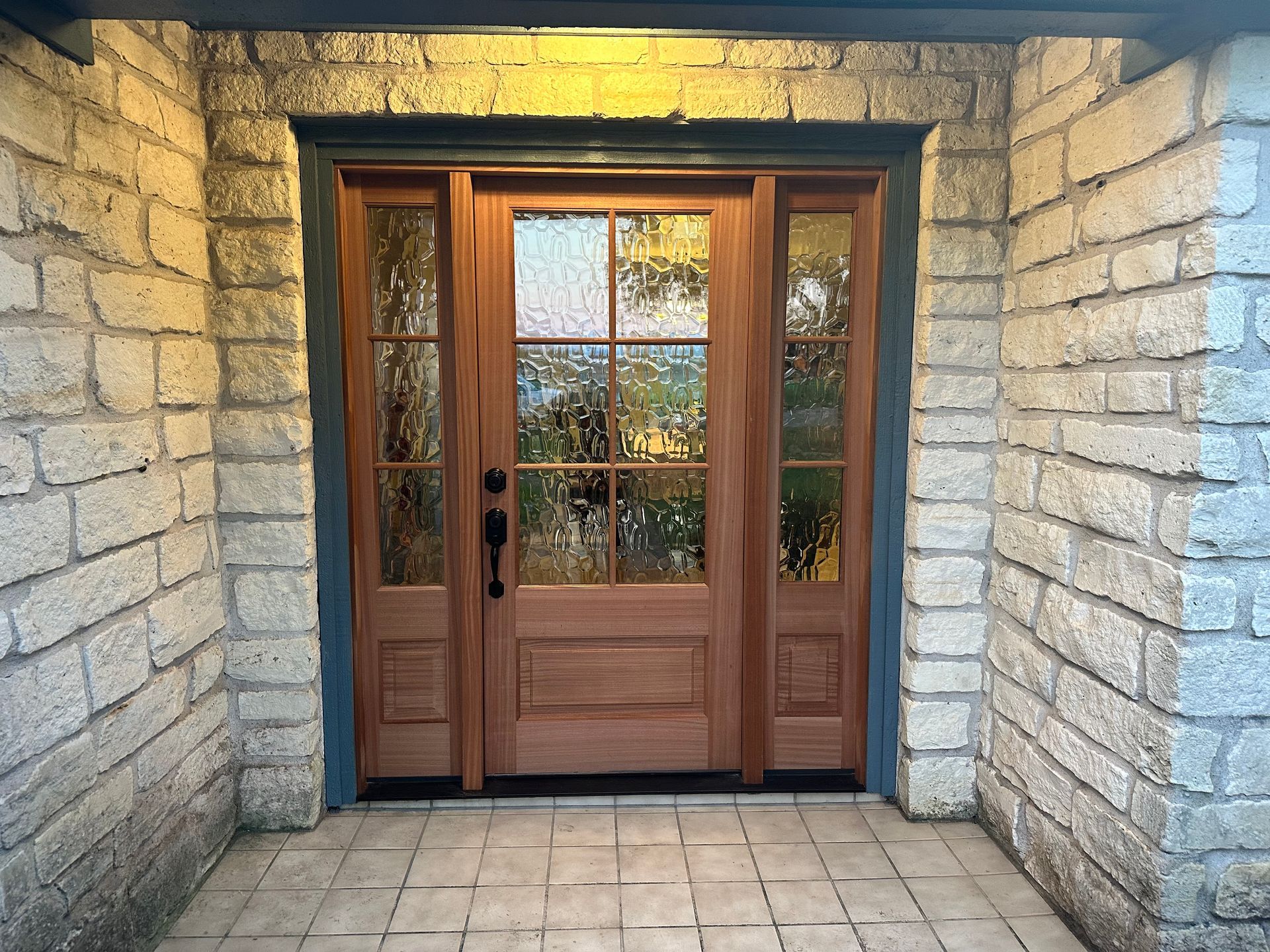 A brick building with a wooden door and glass windows