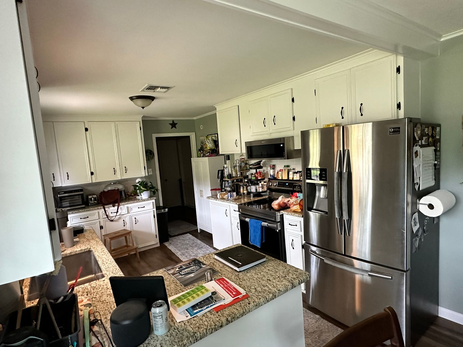 A kitchen with stainless steel appliances and white cabinets.