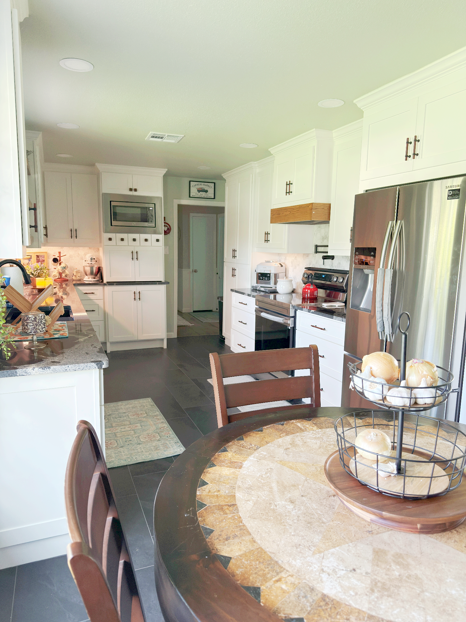 A kitchen with a table and chairs and a refrigerator.