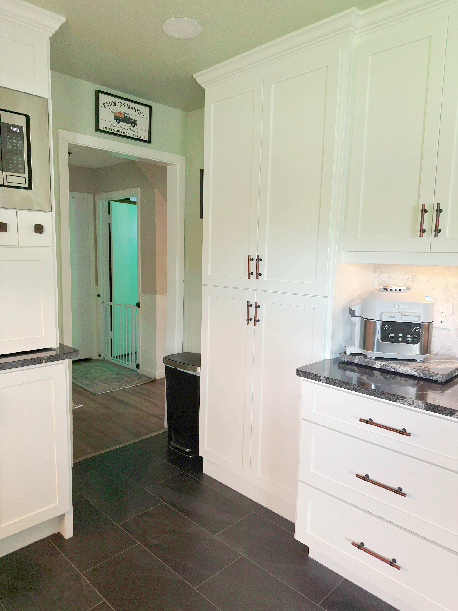 A kitchen with white cabinets and black counter tops