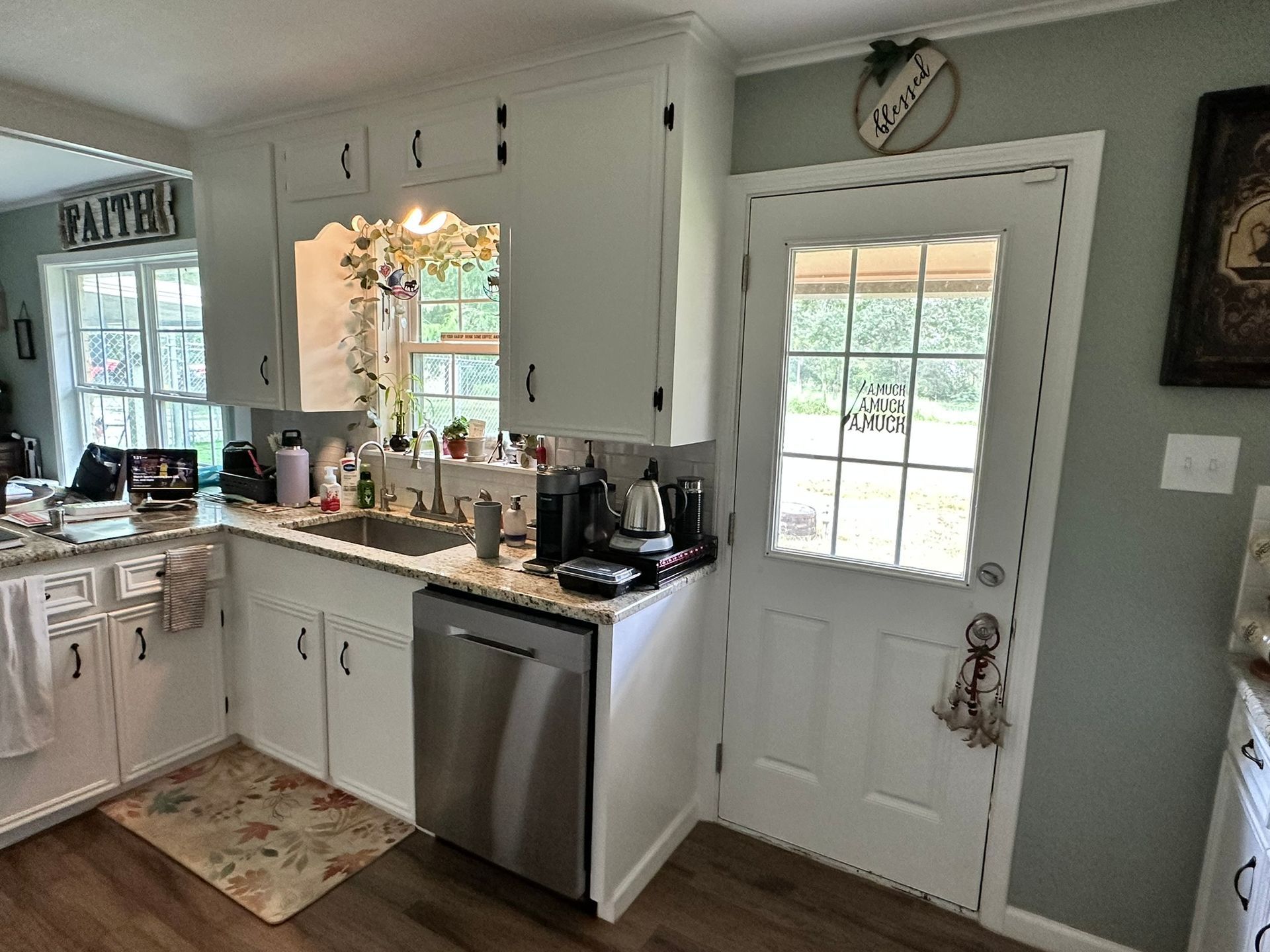 A kitchen with white cabinets and a stainless steel dishwasher.