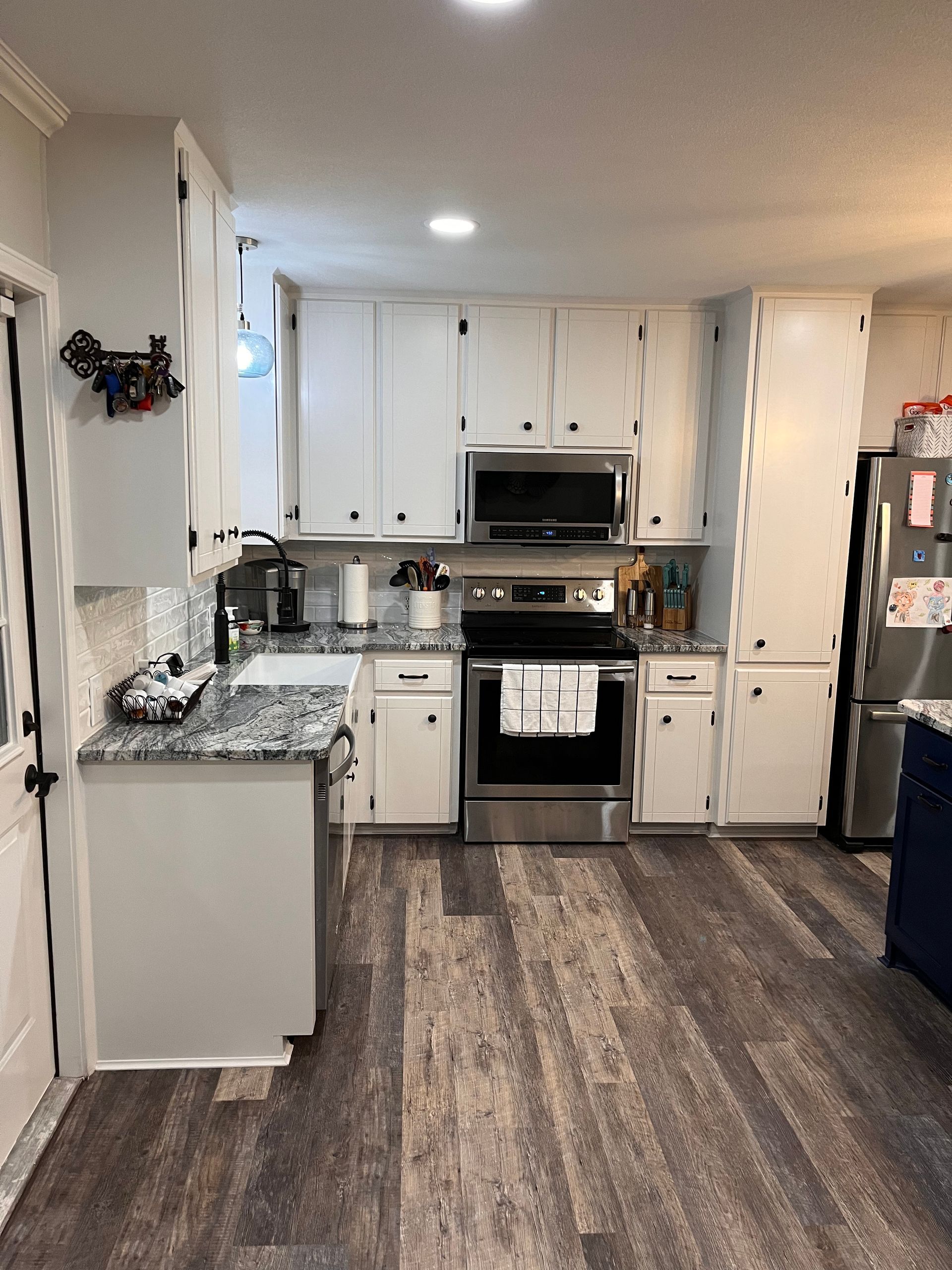 A kitchen with white cabinets and stainless steel appliances