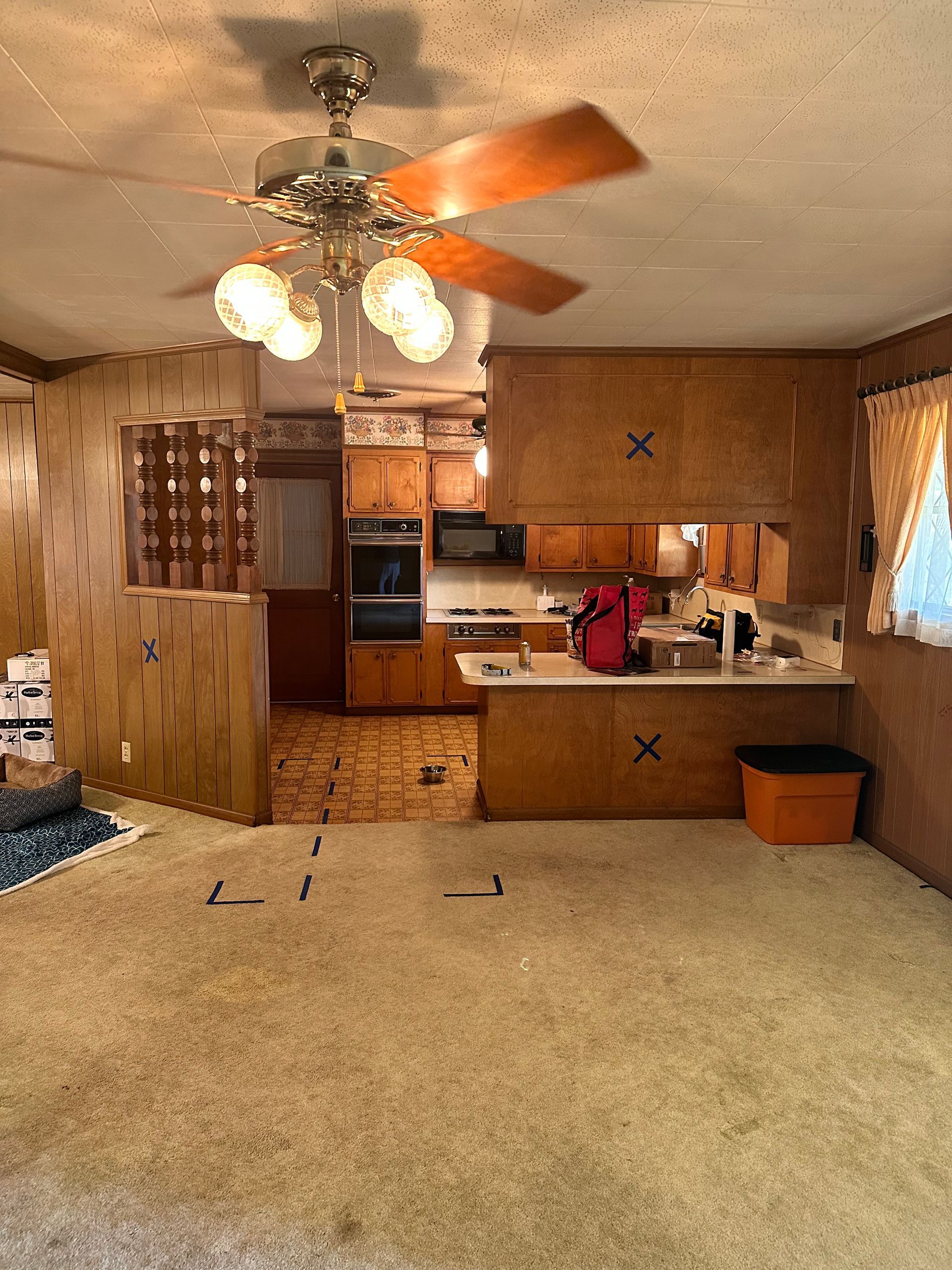 A kitchen in a mobile home with a ceiling fan.