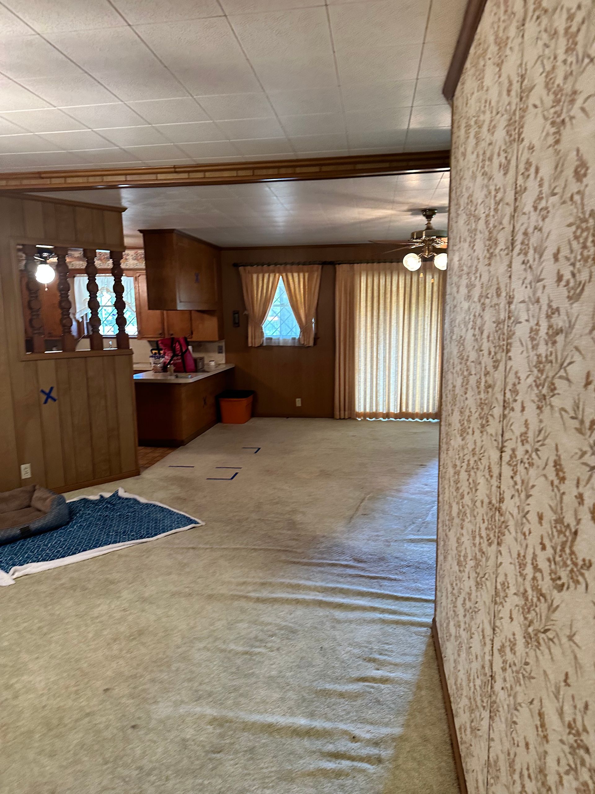 A hallway leading to a kitchen in a mobile home.