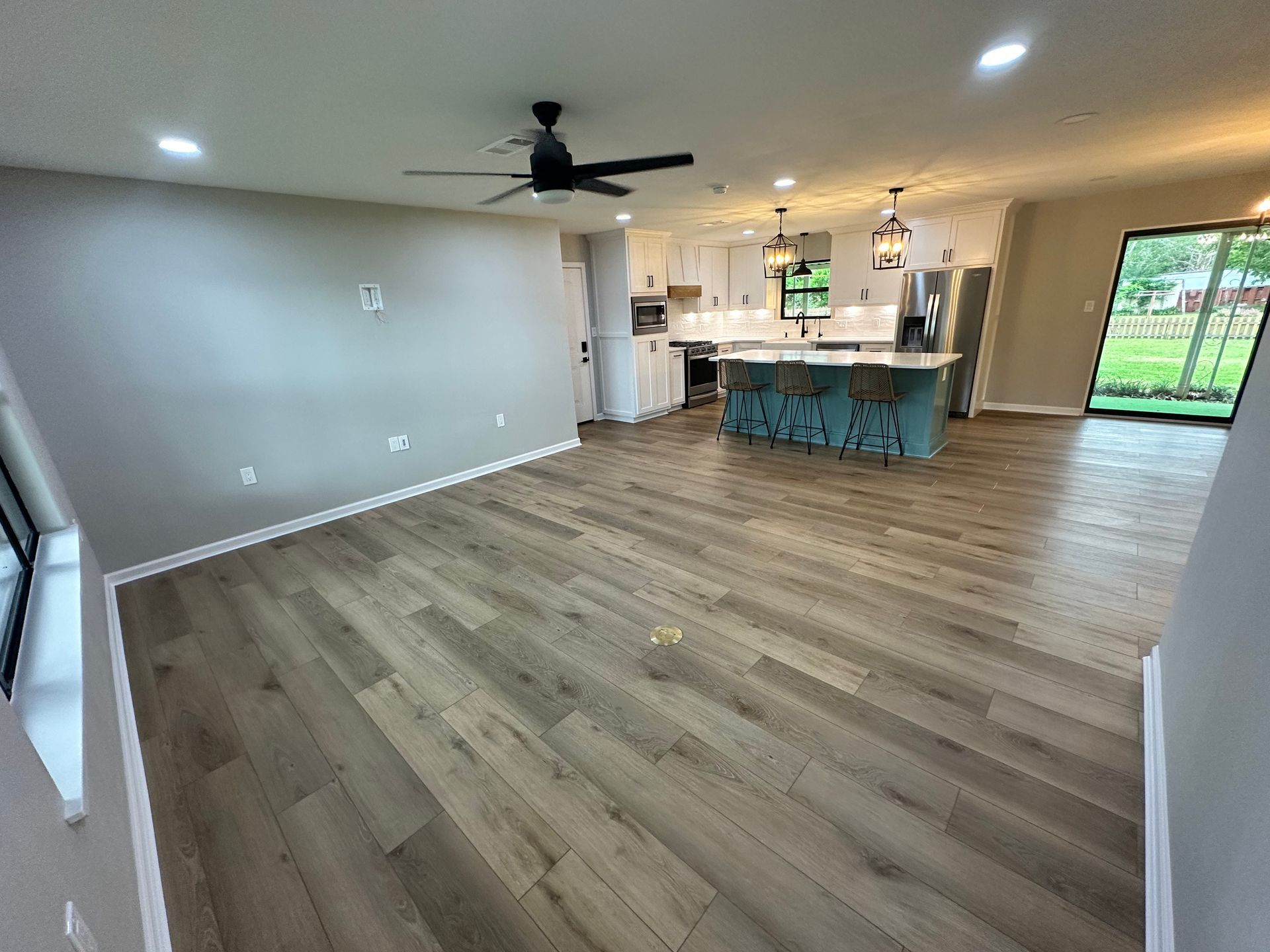 A living room with hardwood floors and a ceiling fan.