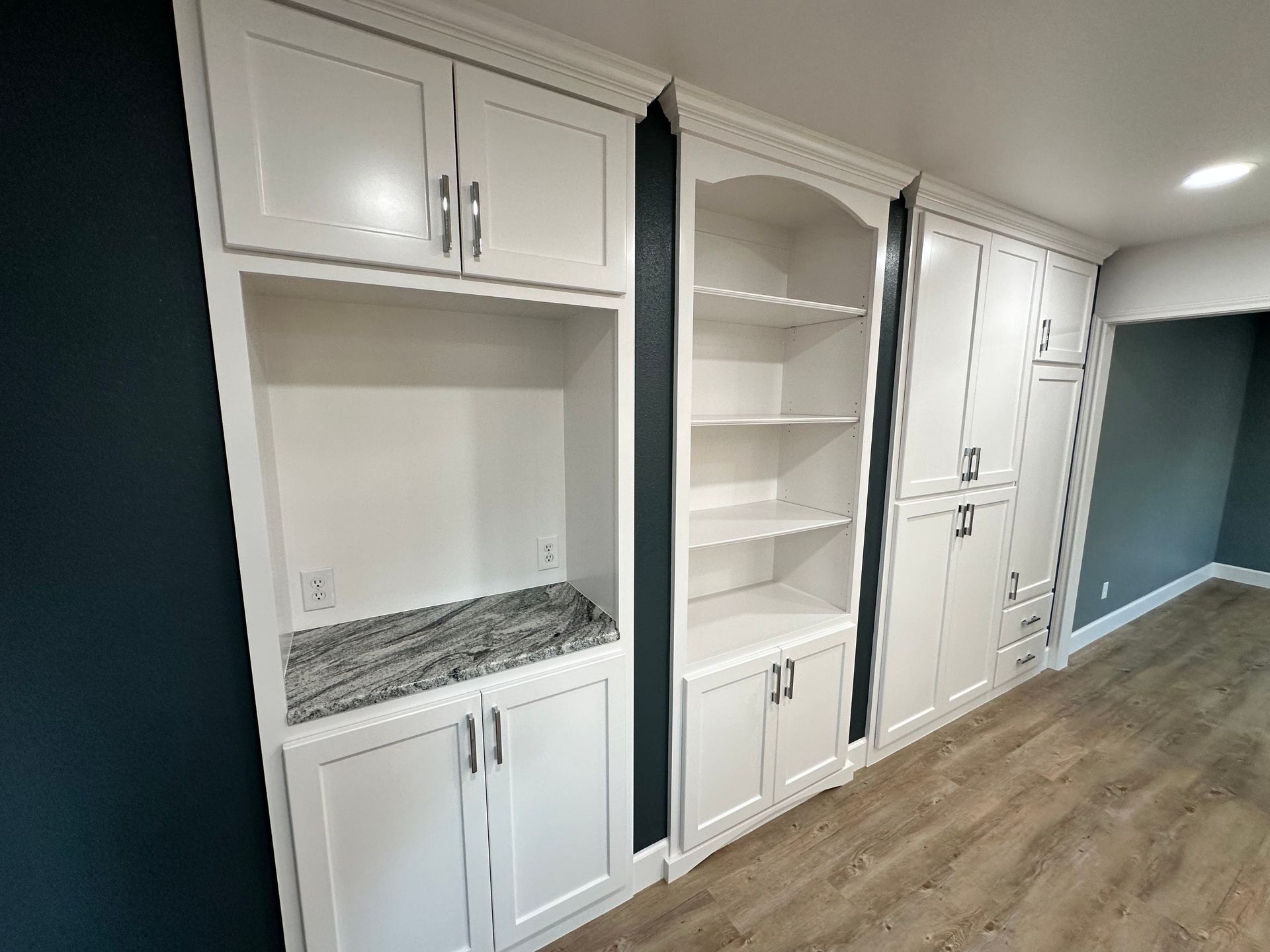 A room with a lot of cabinets and shelves and a wooden floor.