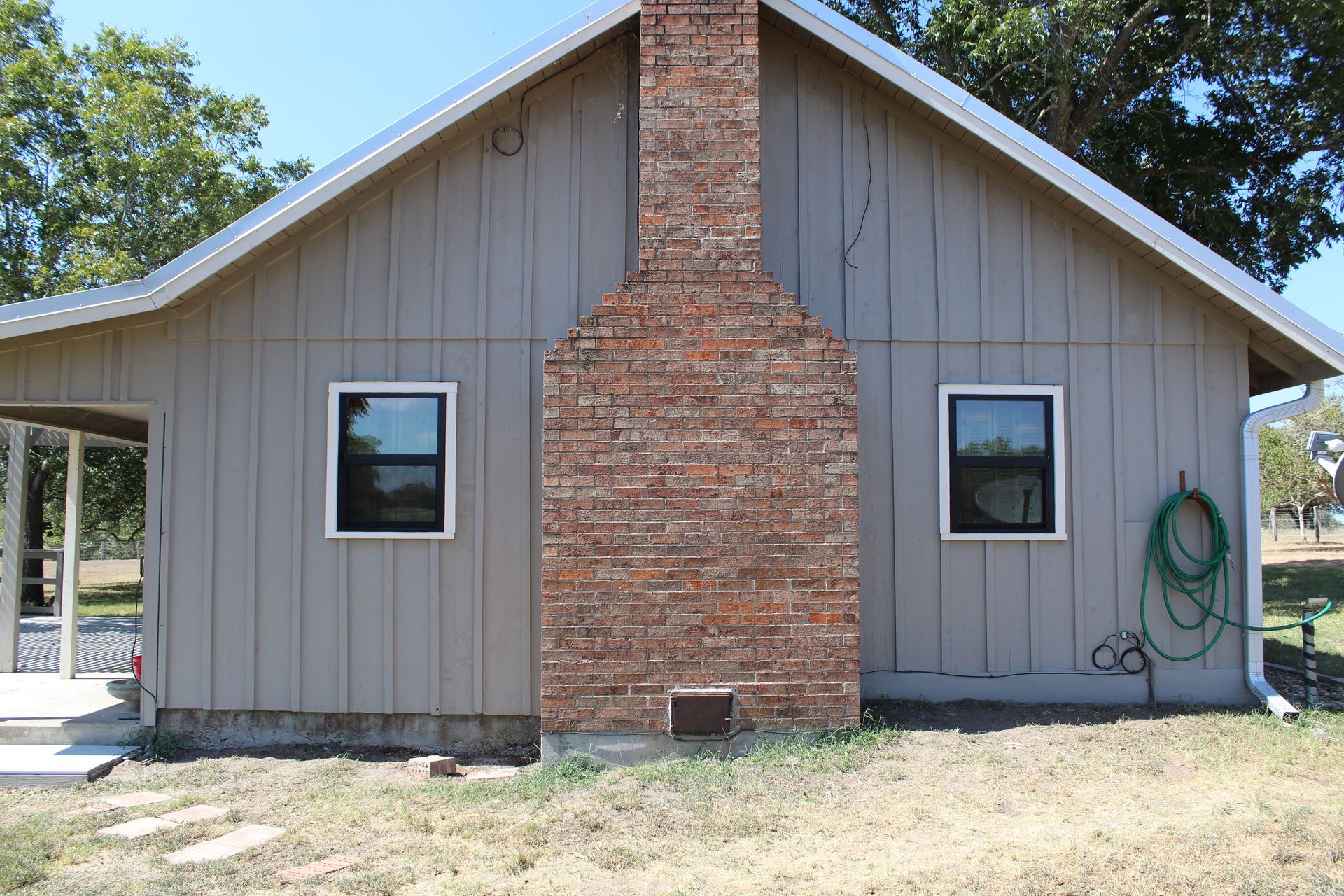 A house with a brick chimney and two windows