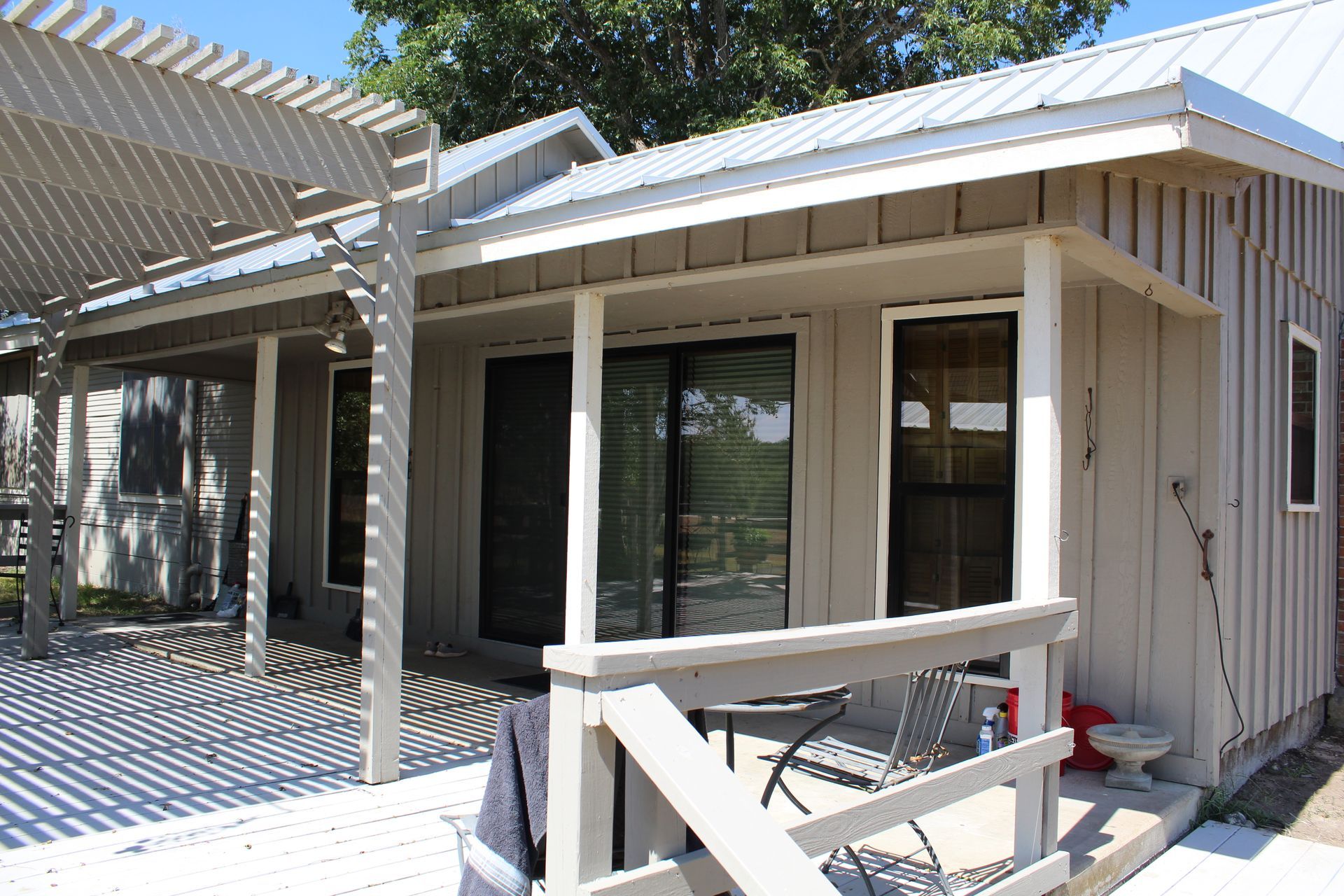 A white house with a porch and a sliding glass door