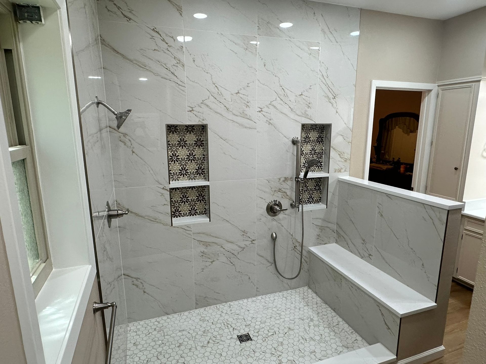 A bathroom with a walk in shower and a window.