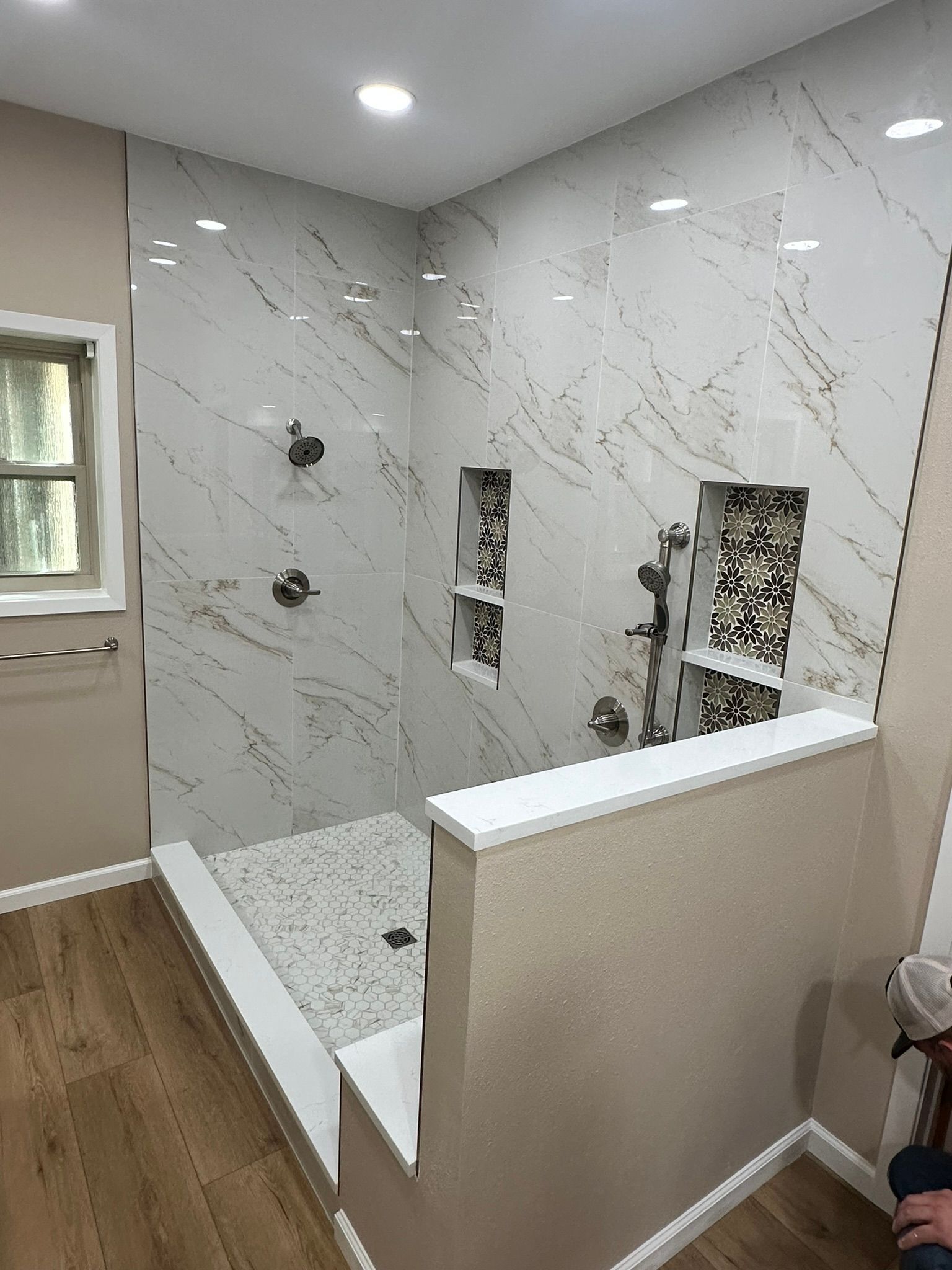 A bathroom with a walk in shower and a window.