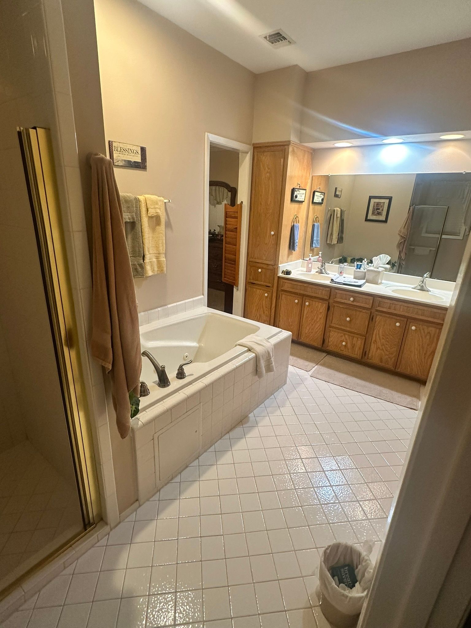 A bathroom with a tub , sinks , and mirrors.