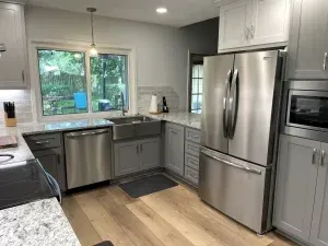 A kitchen with stainless steel appliances , a sink , and a refrigerator.